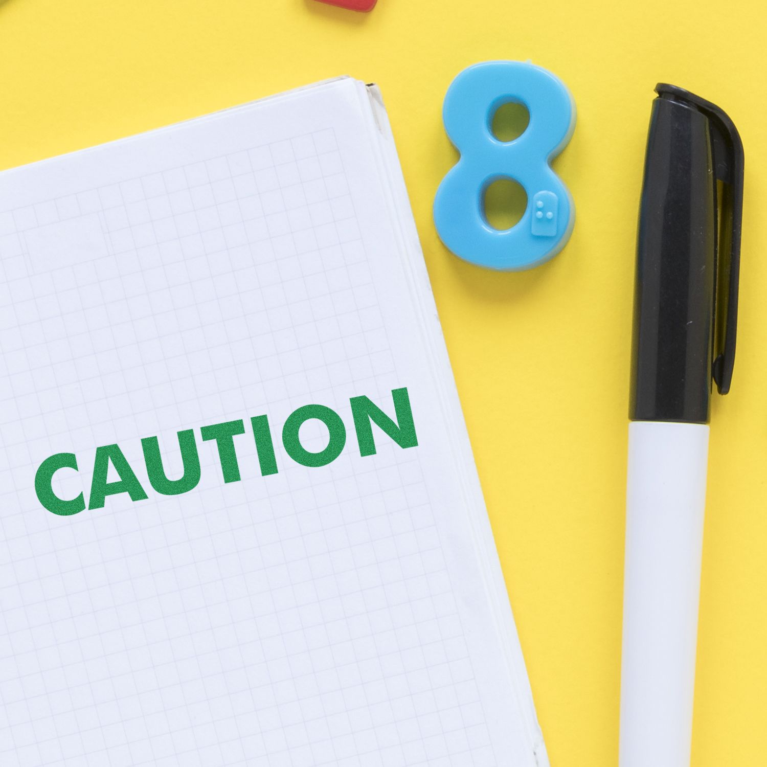 Caution warning notebook with blue number 8 and marker on yellow background