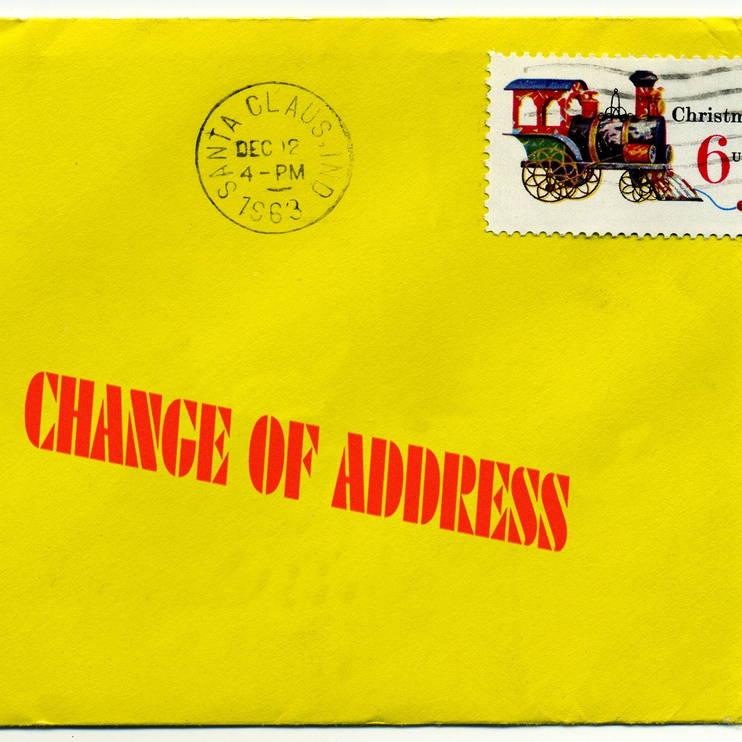 Yellow envelope marked Change of Address, with postal postmark and Christmas train postage stamp for mailing info.