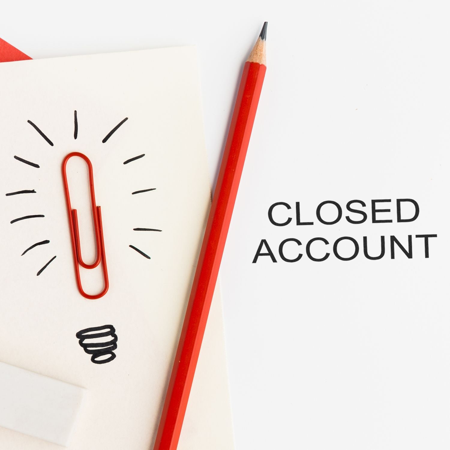 Closed account concept with red pencil, paperclip lightbulb sketch, and bold text on white paper.