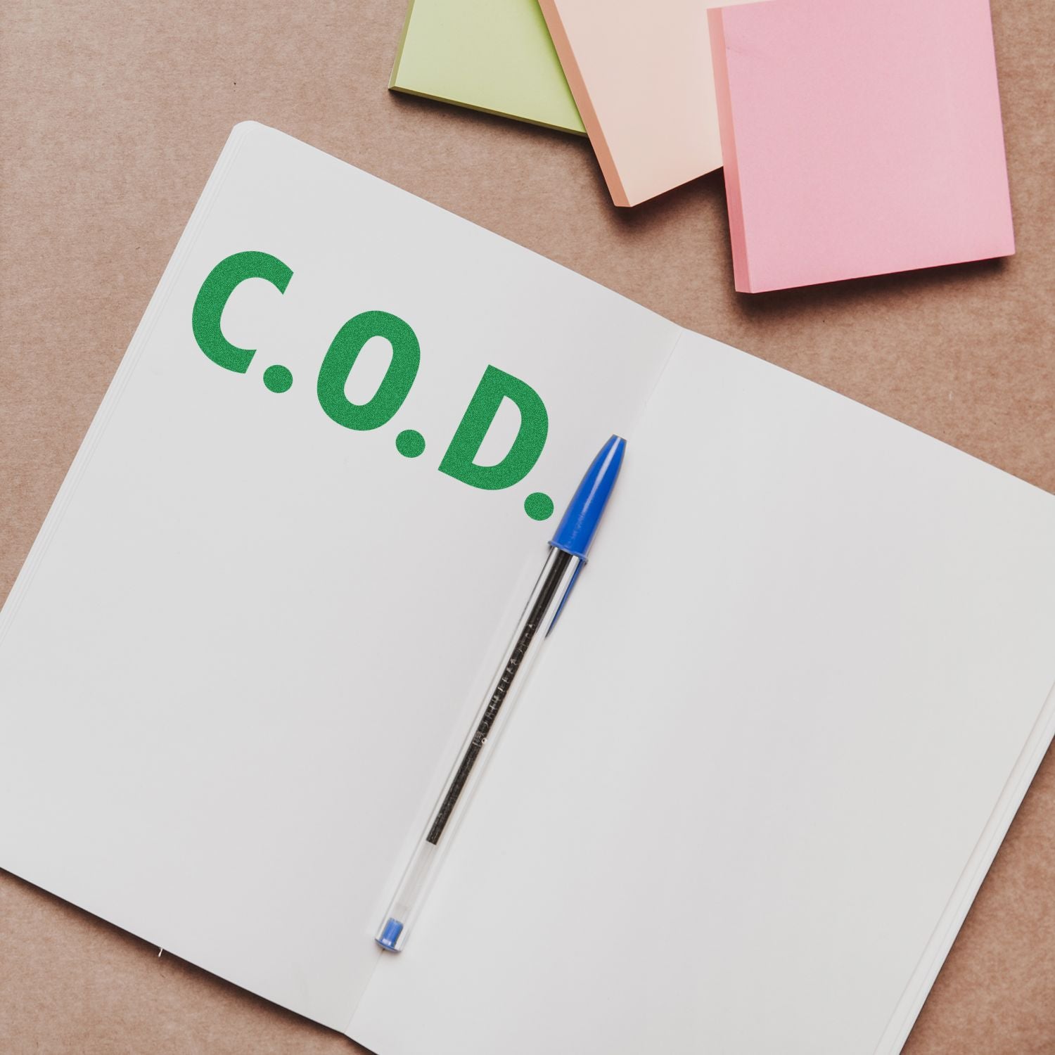 Notebook page with 'C.O.D.' and blue pen, highlighting coding documentation and software development planning on desk for programmers.