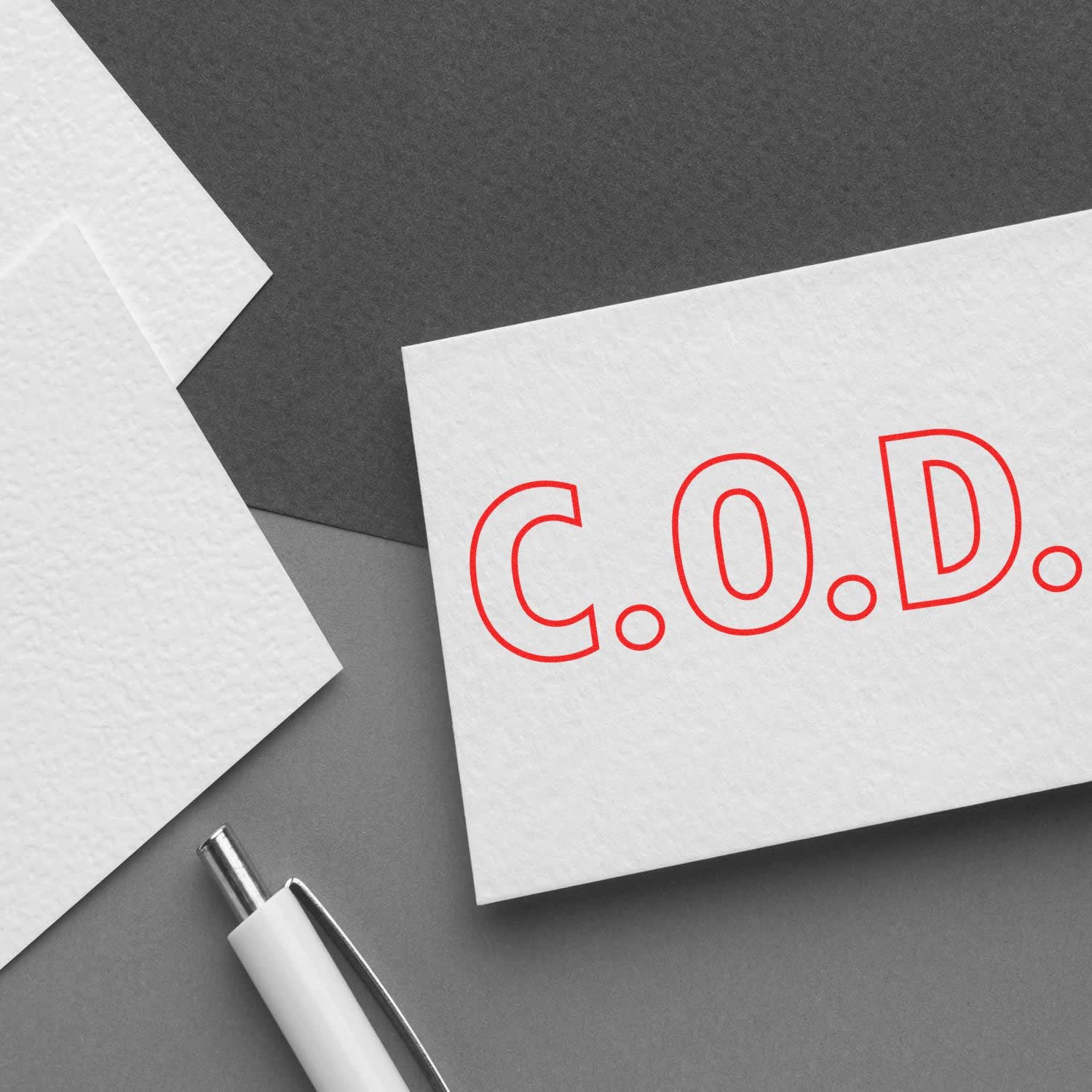 C.O.D. cash on delivery payment concept: white card with red 'C.O.D.' letters and pen on grey background.