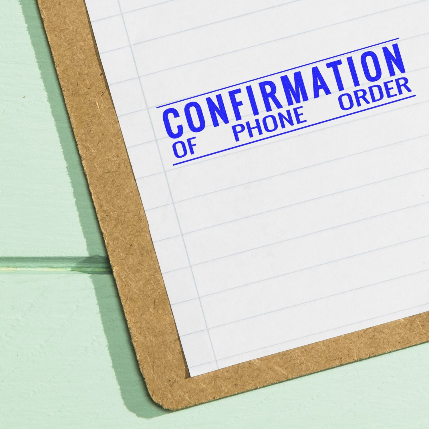 Confirmation of phone order stamped on clipboard with lined paper, business document close-up.