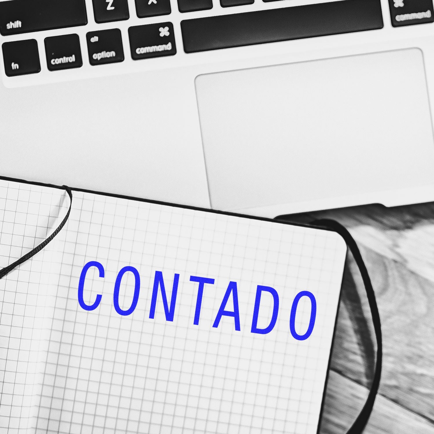 Laptop keyboard beside a notebook labeled CONTADO, concept of accounting and financial management.