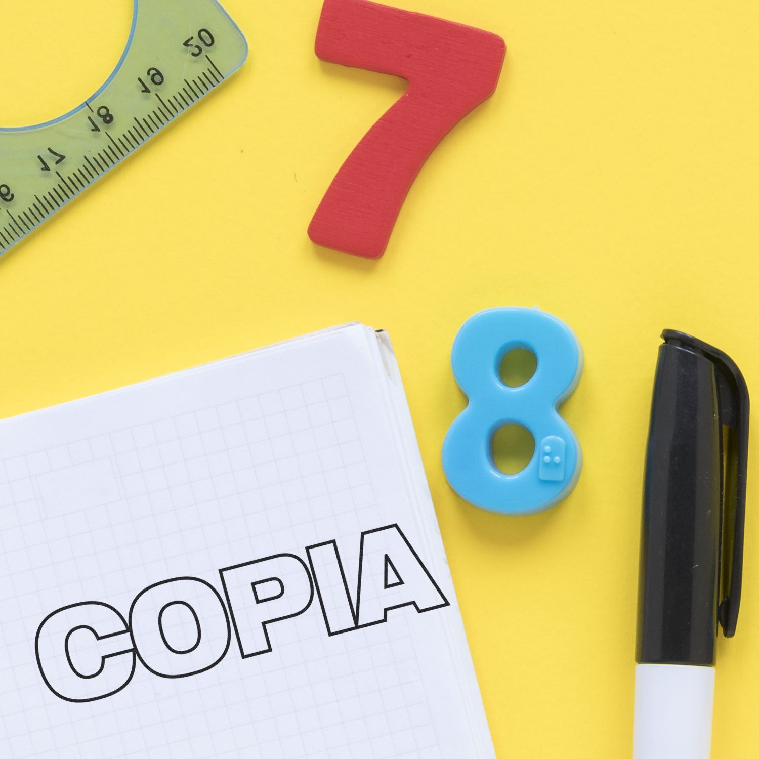 School supplies on yellow background with notebook labeled COPIA, number blocks 7 and 8, ruler, and marker.