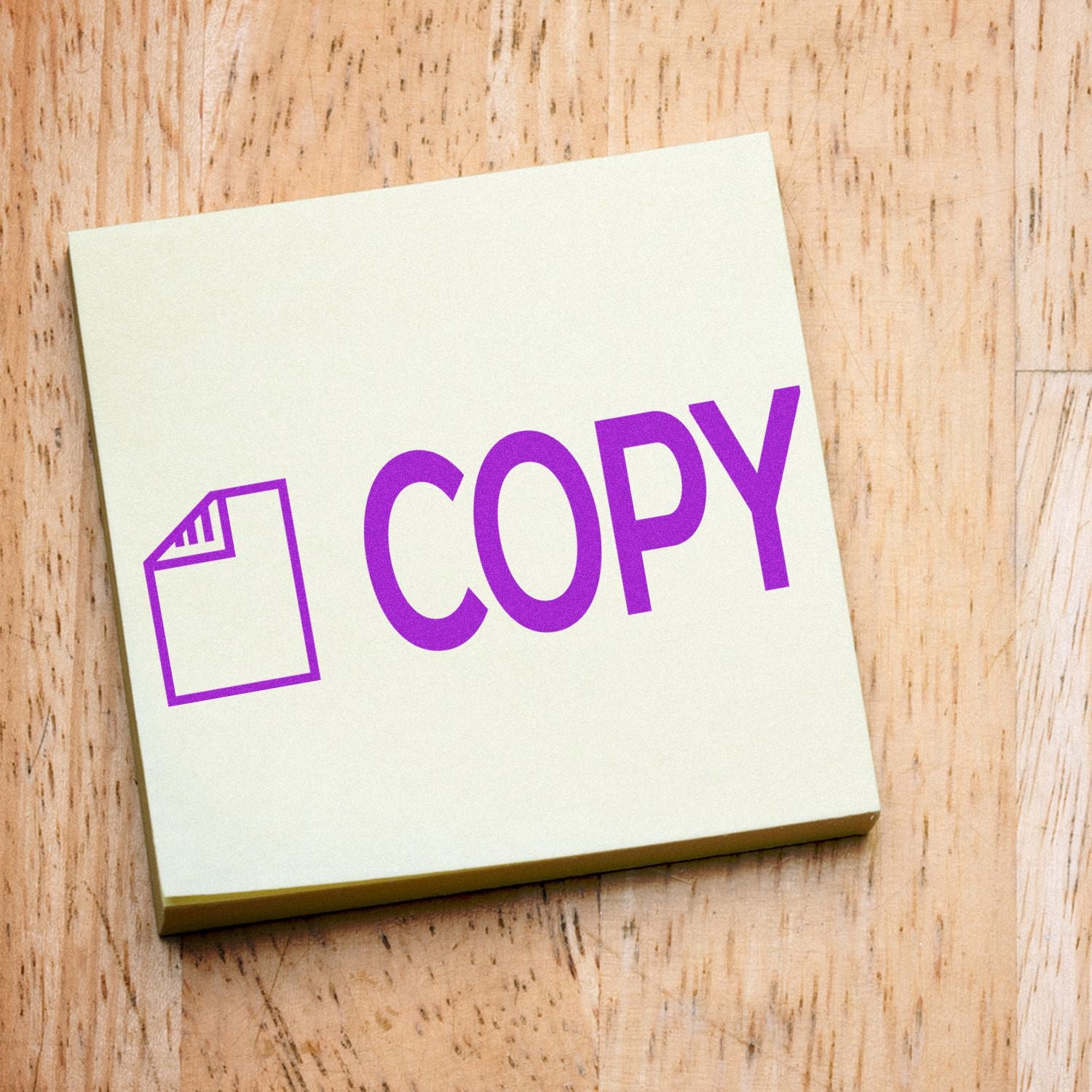 Purple COPY icon on a sticky note on a wooden background.