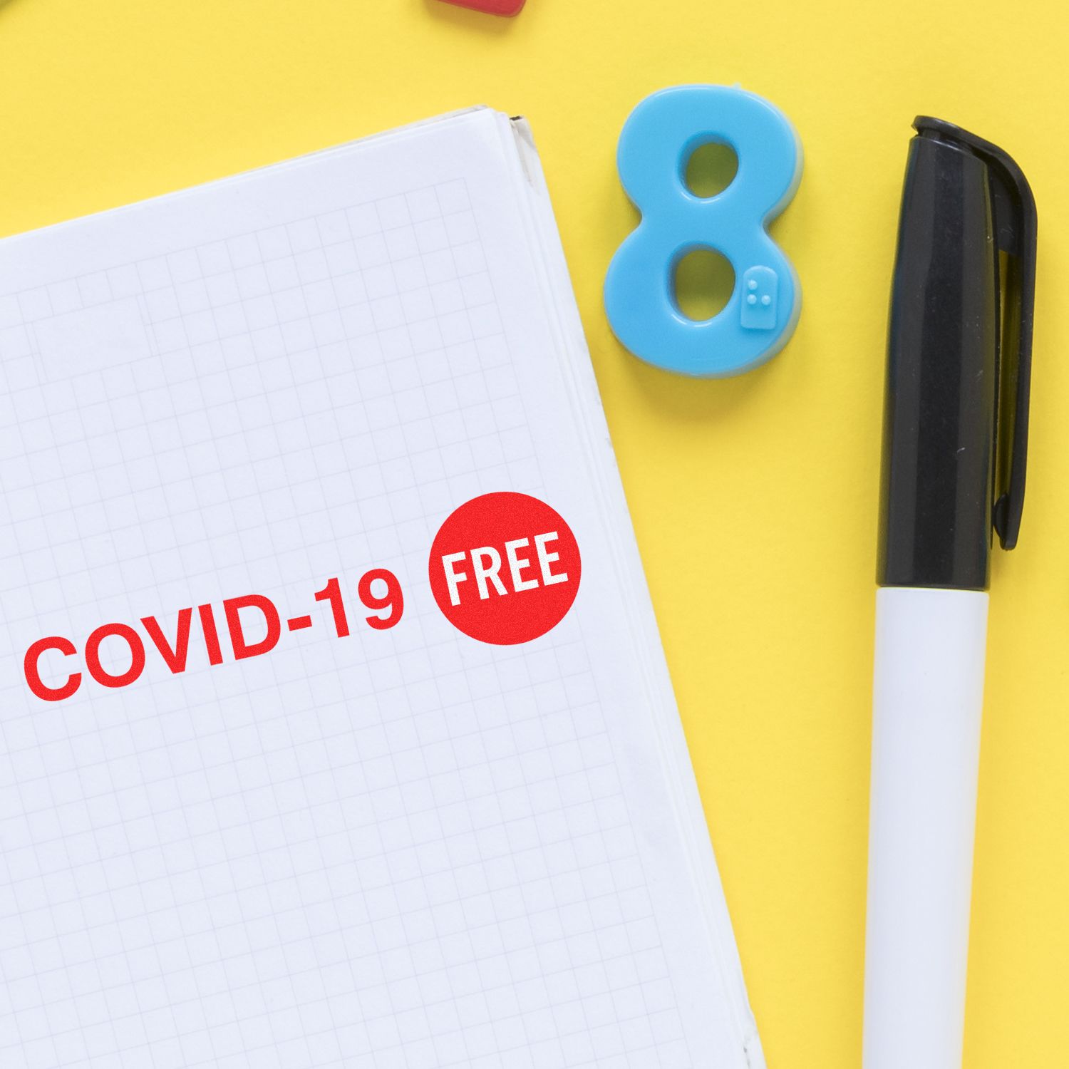COVID-19 free message on notebook with pen and stamp, representing health safety during the pandemic