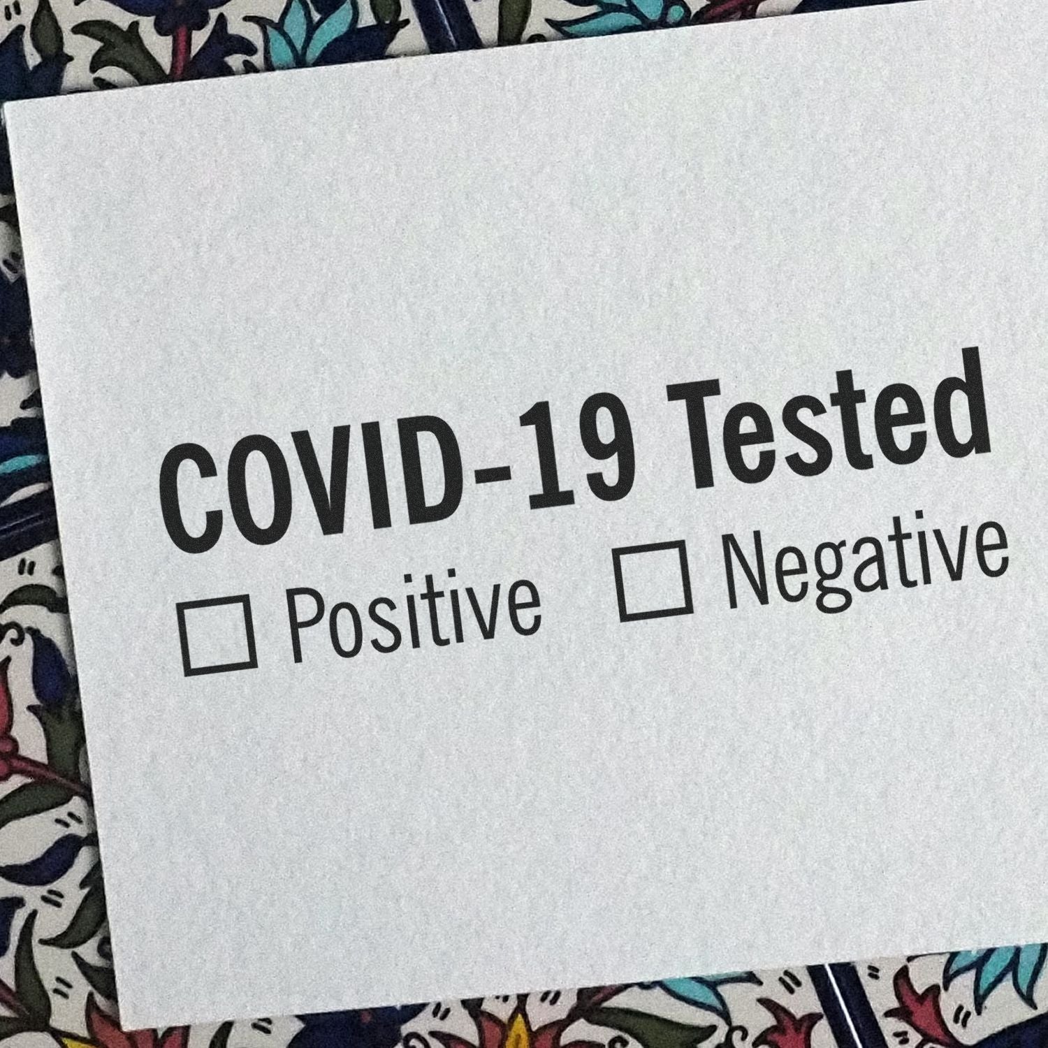 Close-up of a COVID-19 test result placard showing Positive and Negative checkboxes for interpreting COVID-19 test outcomes.