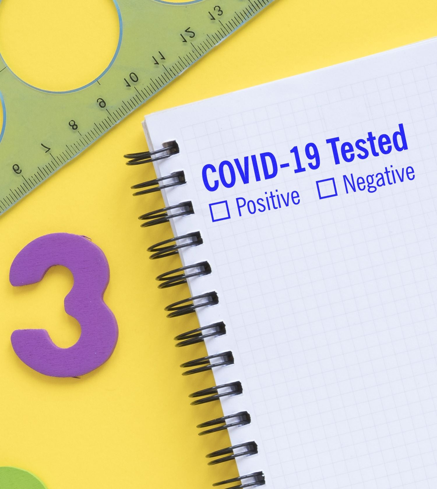 COVID-19 test notebook showing Tested with checkboxes for Positive and Negative results, health screening concept.