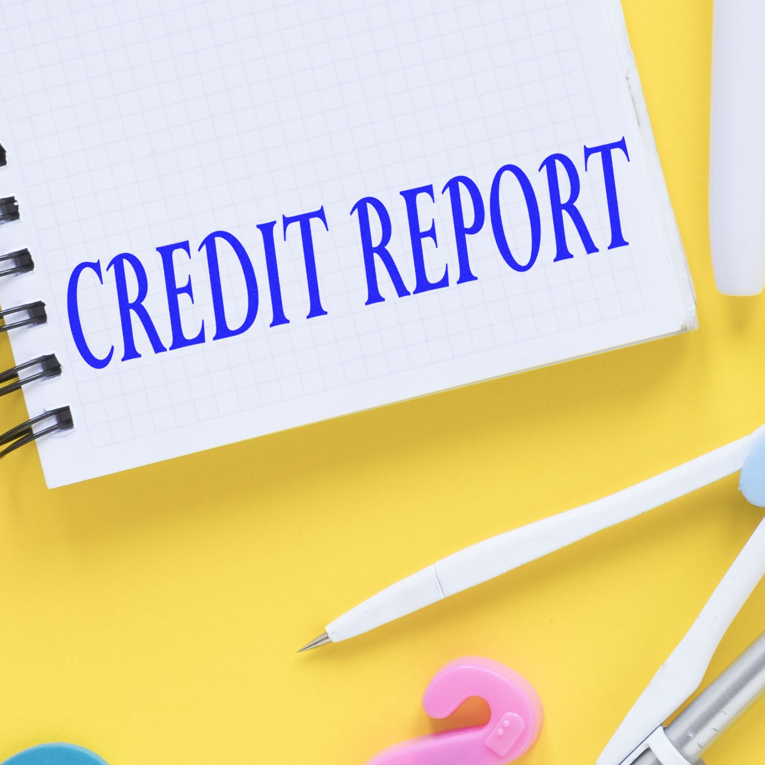 Notebook page with CREDIT REPORT title on yellow desk, illustrating credit score checks and credit repair services.