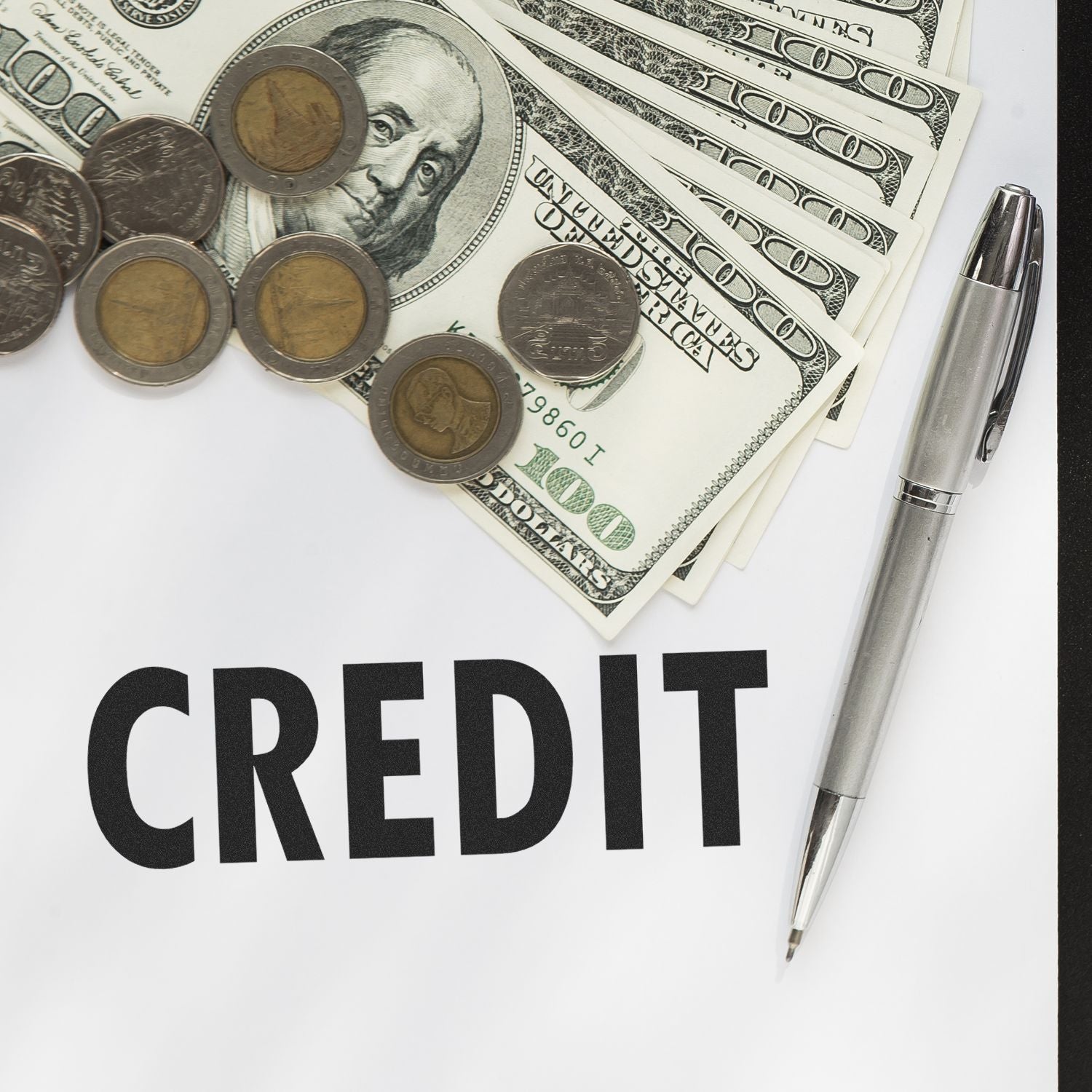 Credit concept image with US dollar bills, coins, and pen, highlighting credit finance and budgeting.