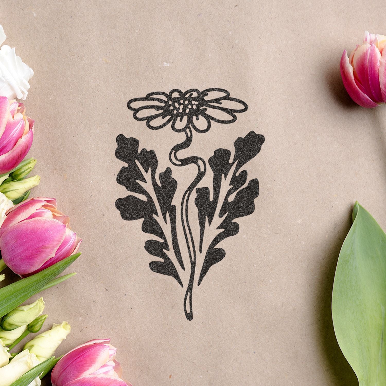 Black floral silhouette design on kraft paper surrounded by pink tulips and green leaves, elegant flower illustration on rustic background