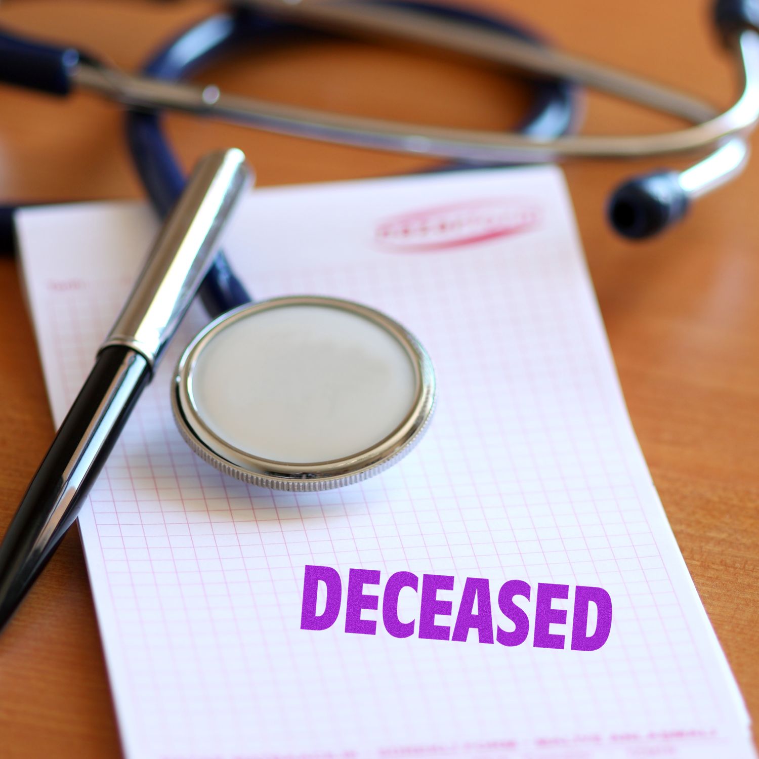 Stethoscope and pen on a document stamped deceased, symbolizing medical death certification and estate paperwork.