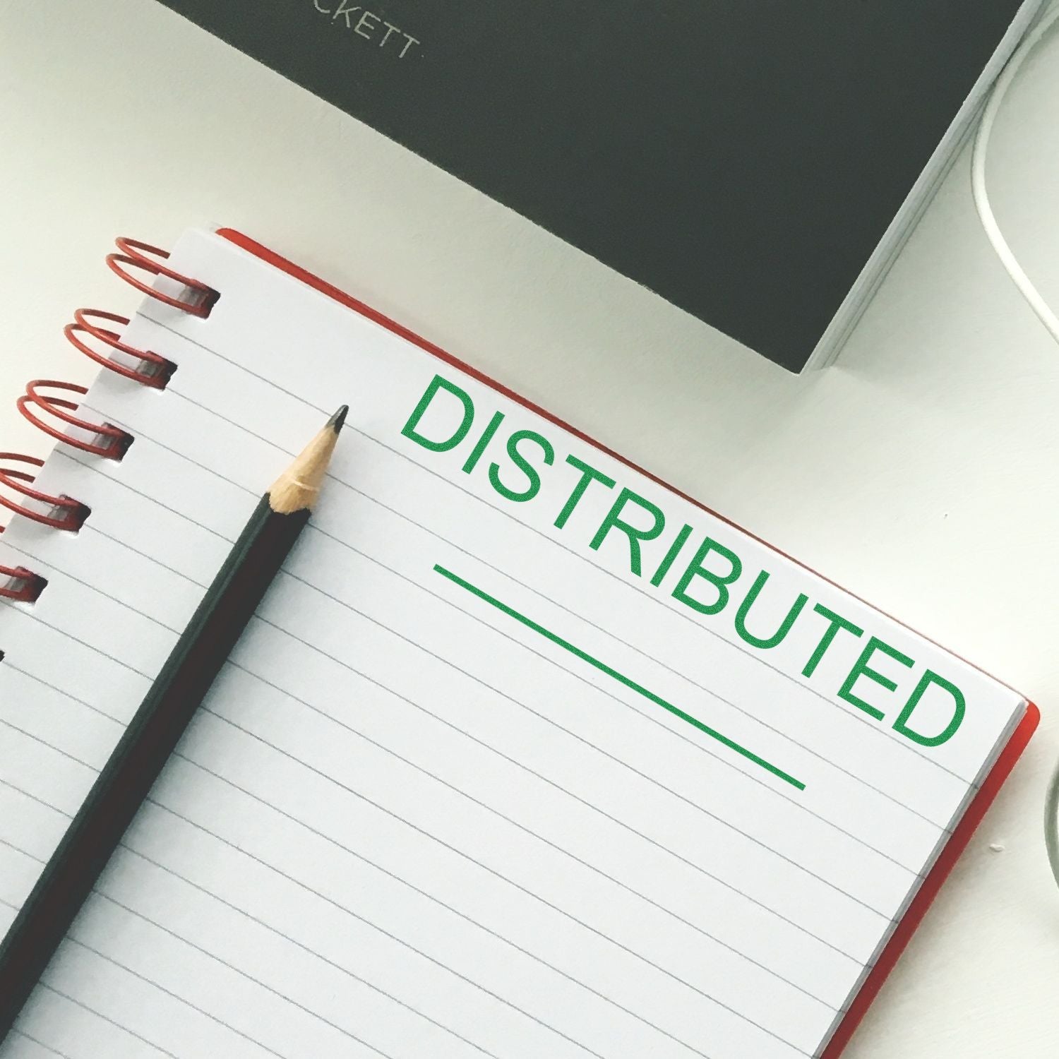 Notebook labeled DISTRIBUTED with pencil, for distributed computing network documentation and project planning notes.