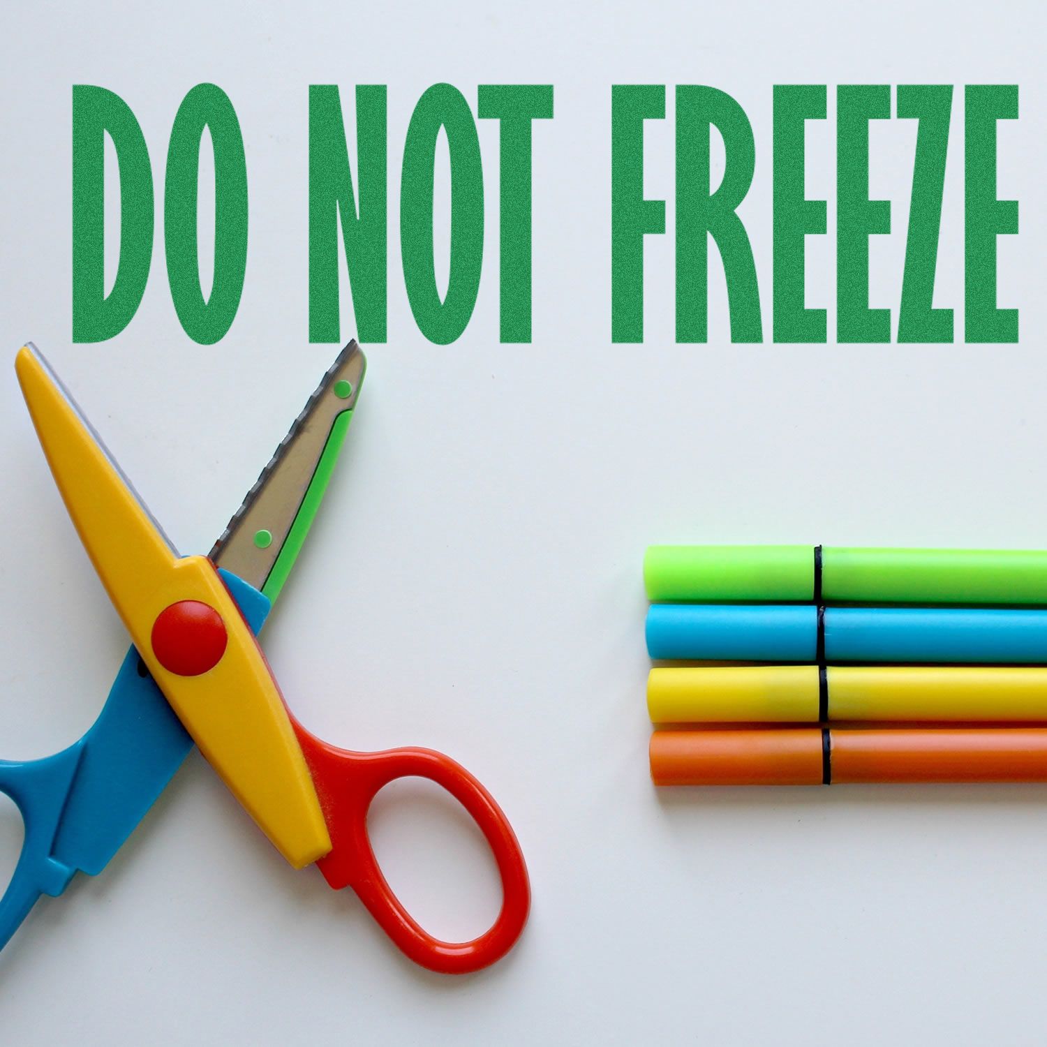 Colorful scissors and markers beside Do Not Freeze text on a white background.