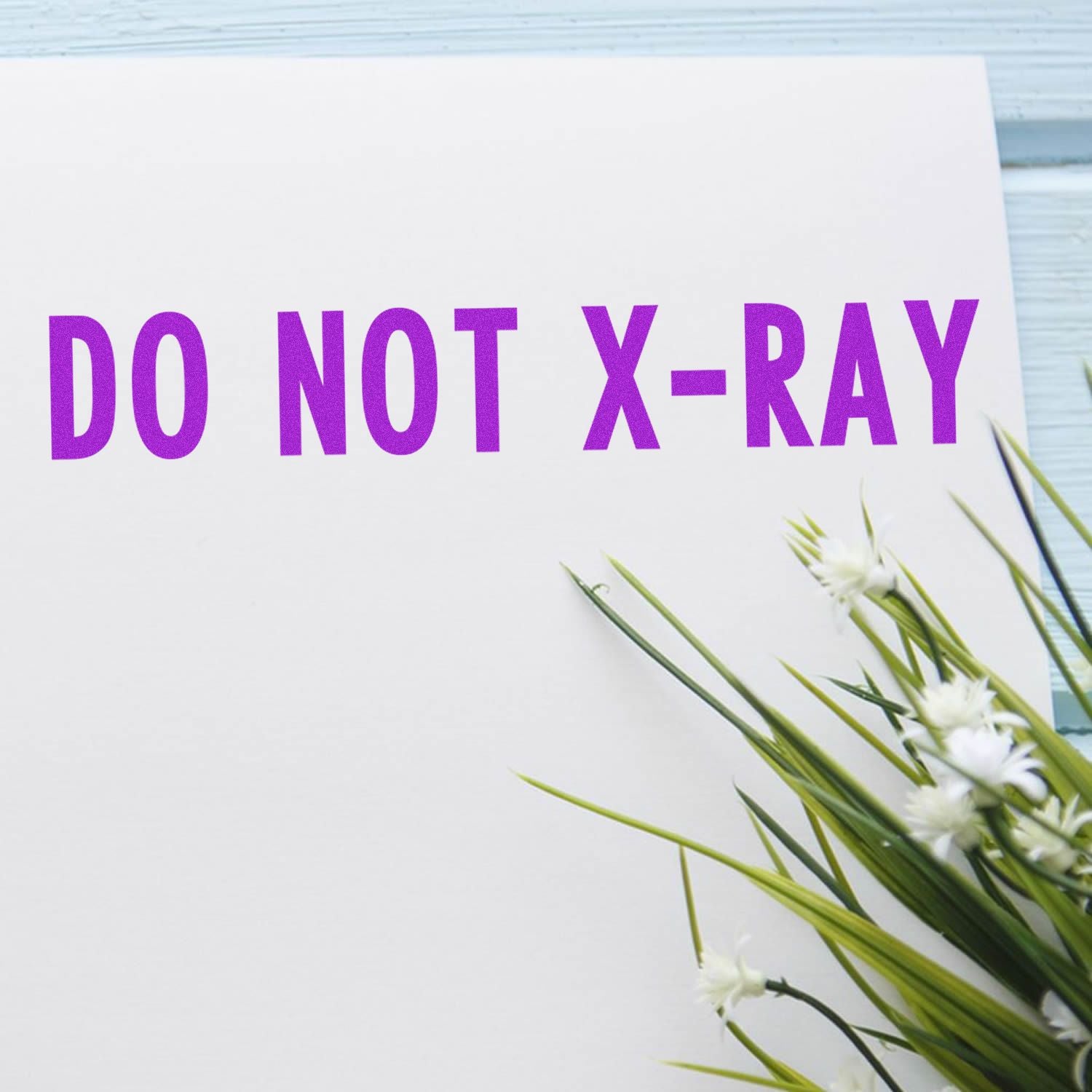 DO NOT X-RAY warning label on white shipping document with flowers, indicating fragile item must not be X-rayed