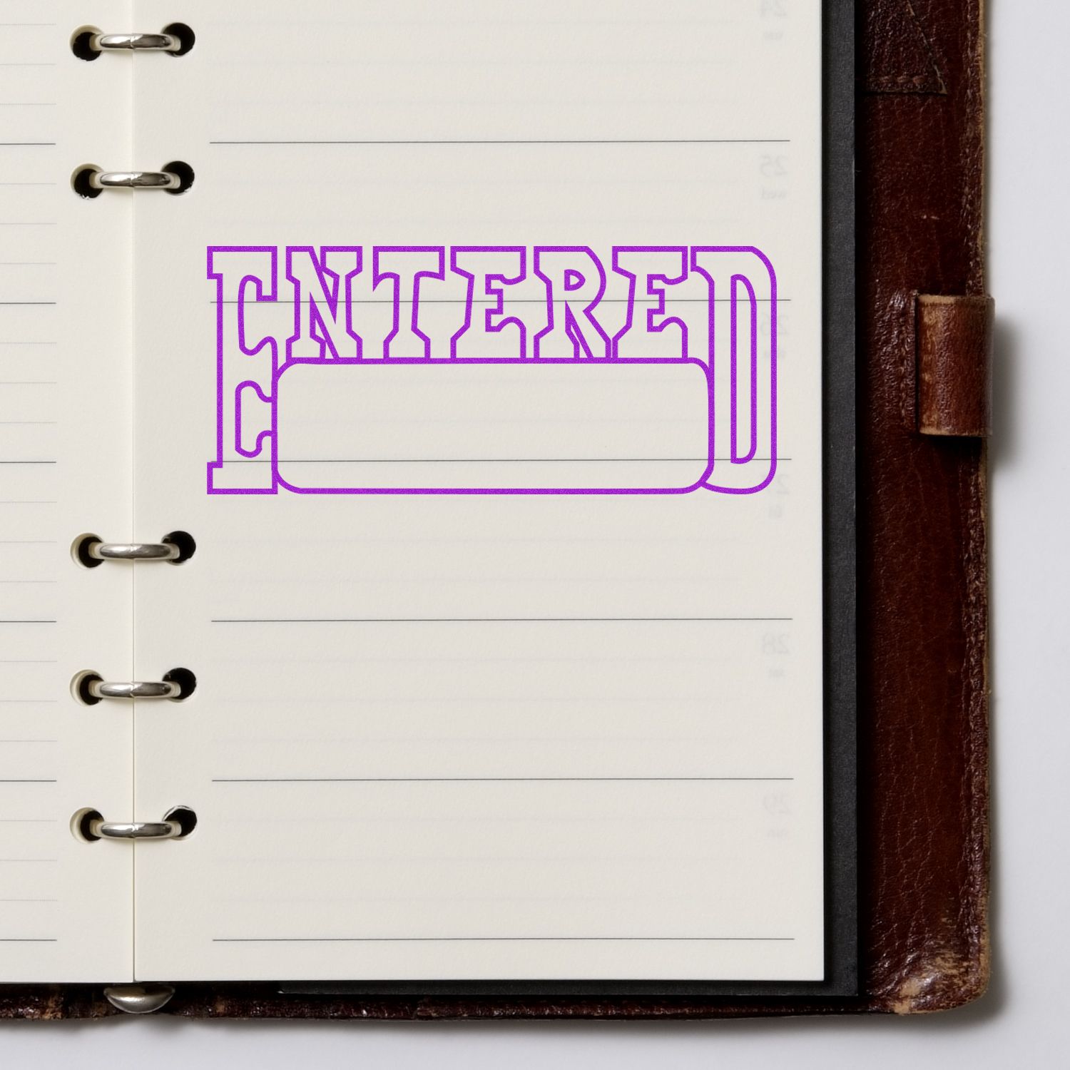 Purple outline stamp reading ENTERED on lined notebook page, illustrating document entry or catalog status.