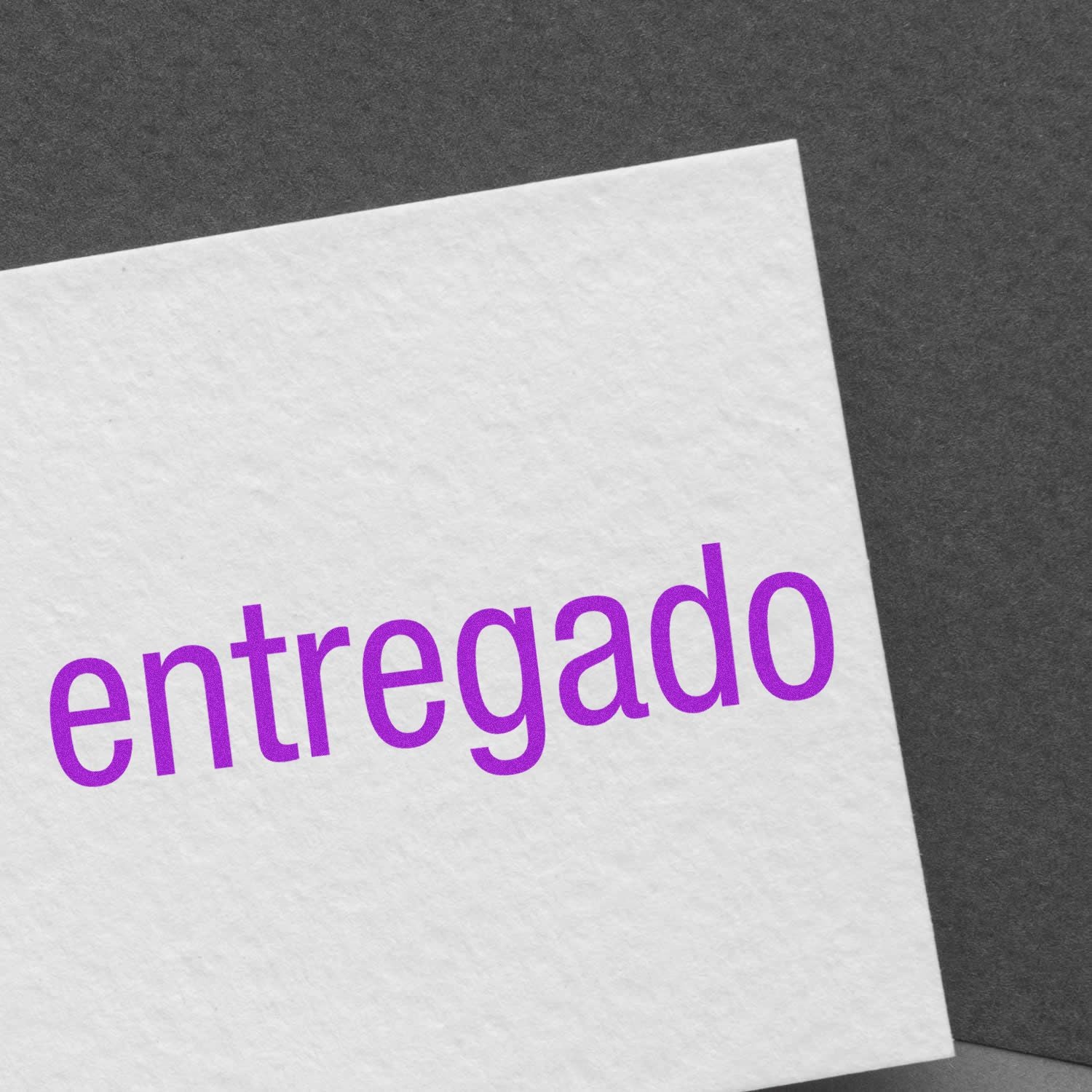 Delivered notice paper with purple entregado text on white sheet, confirming shipping delivery status for e-commerce packages.