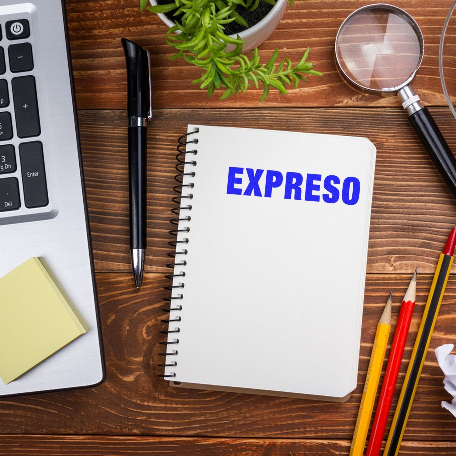 Notebook page reading EXPRESO on wooden desk with pens, laptop, and magnifying glass, illustrating espresso coffee research and planning ideas.