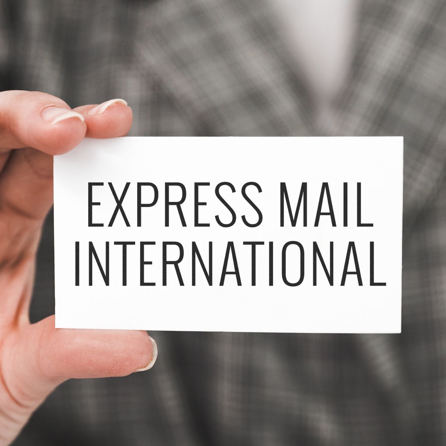 Hand holding a card reading Express Mail International, representing international shipping and express delivery services.