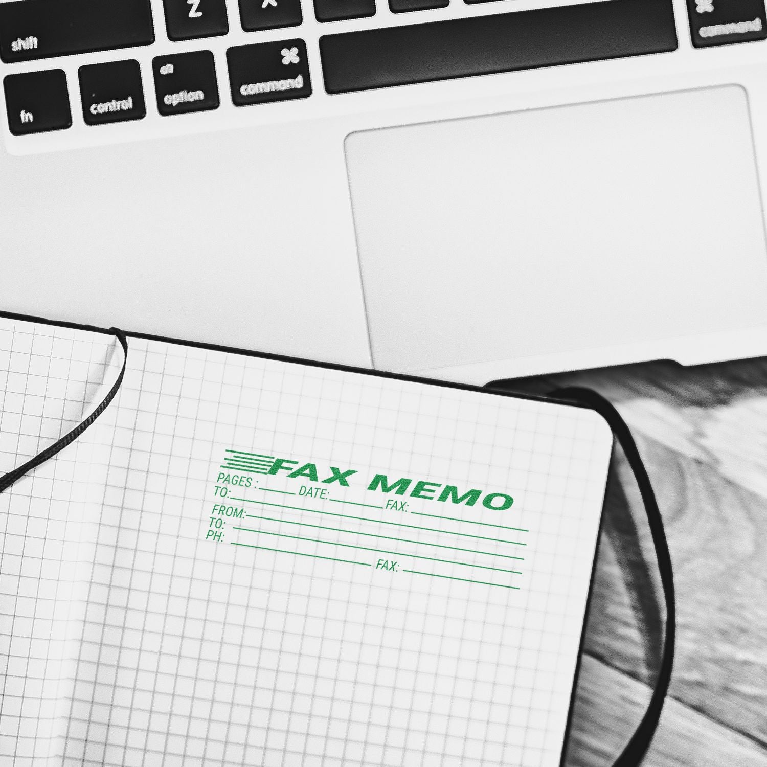 Close-up of laptop keyboard and notebook with fax memo form, office communication concept.