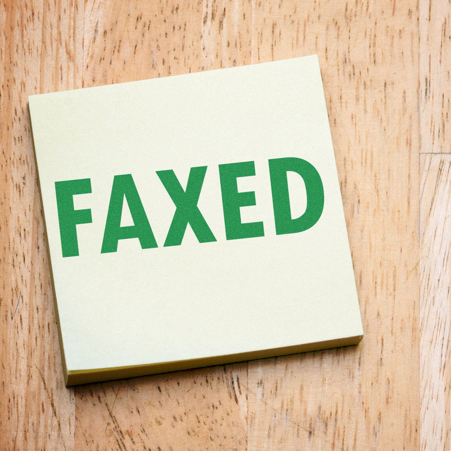 FIXED typography sign on a white paper card on a wooden surface, promoting repair or handyman services.