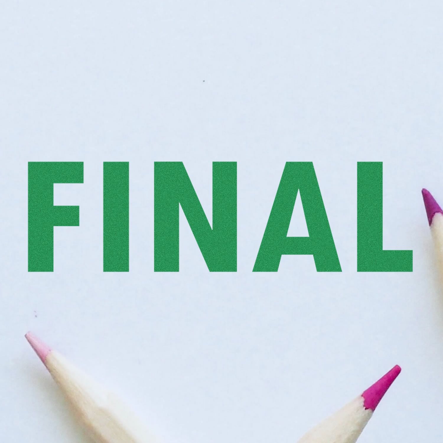 Green word FINAL made with craft letters on white paper, with colored pencils at the edges, signaling completion.