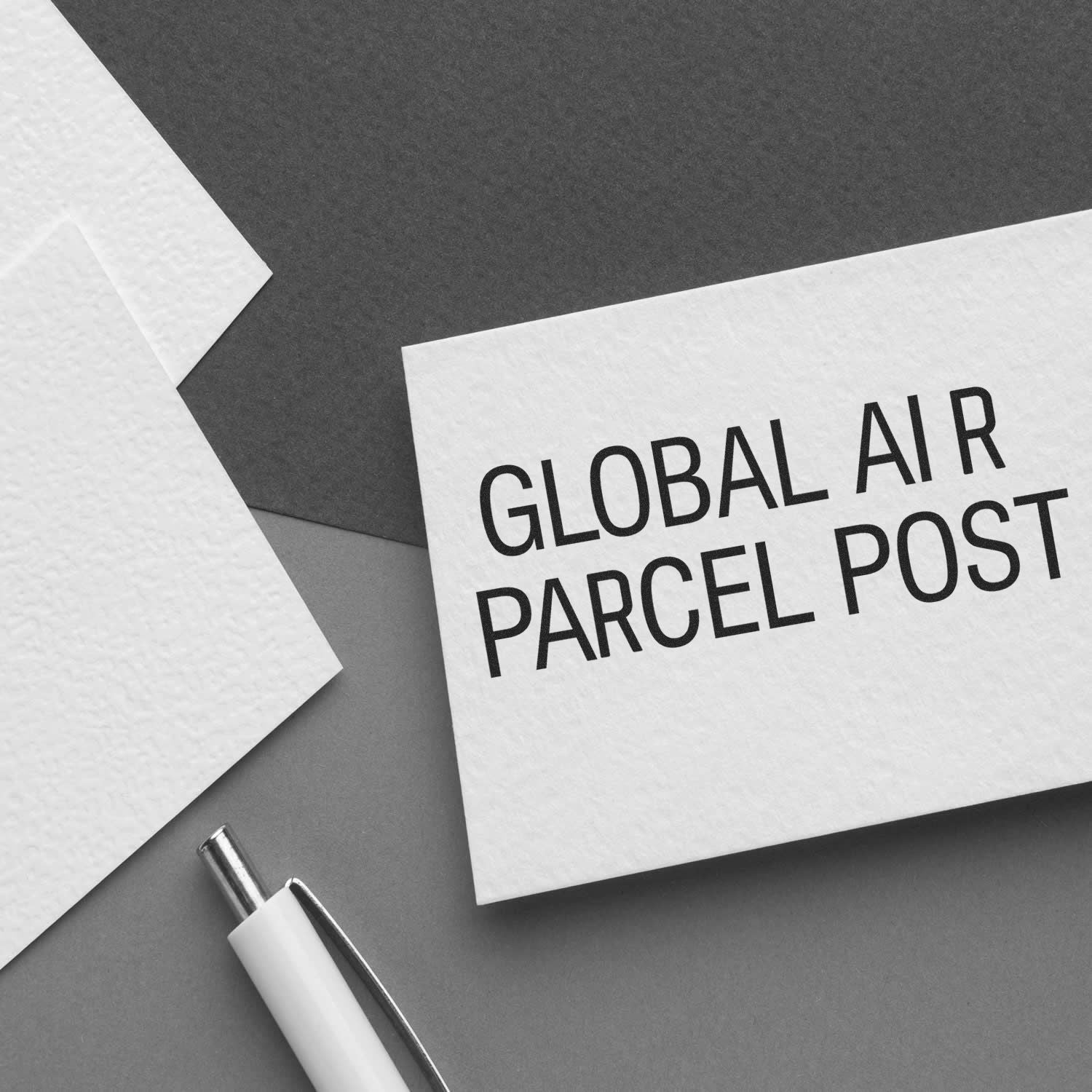 Global air parcel post envelope with pen on gray background, international shipping concept.
