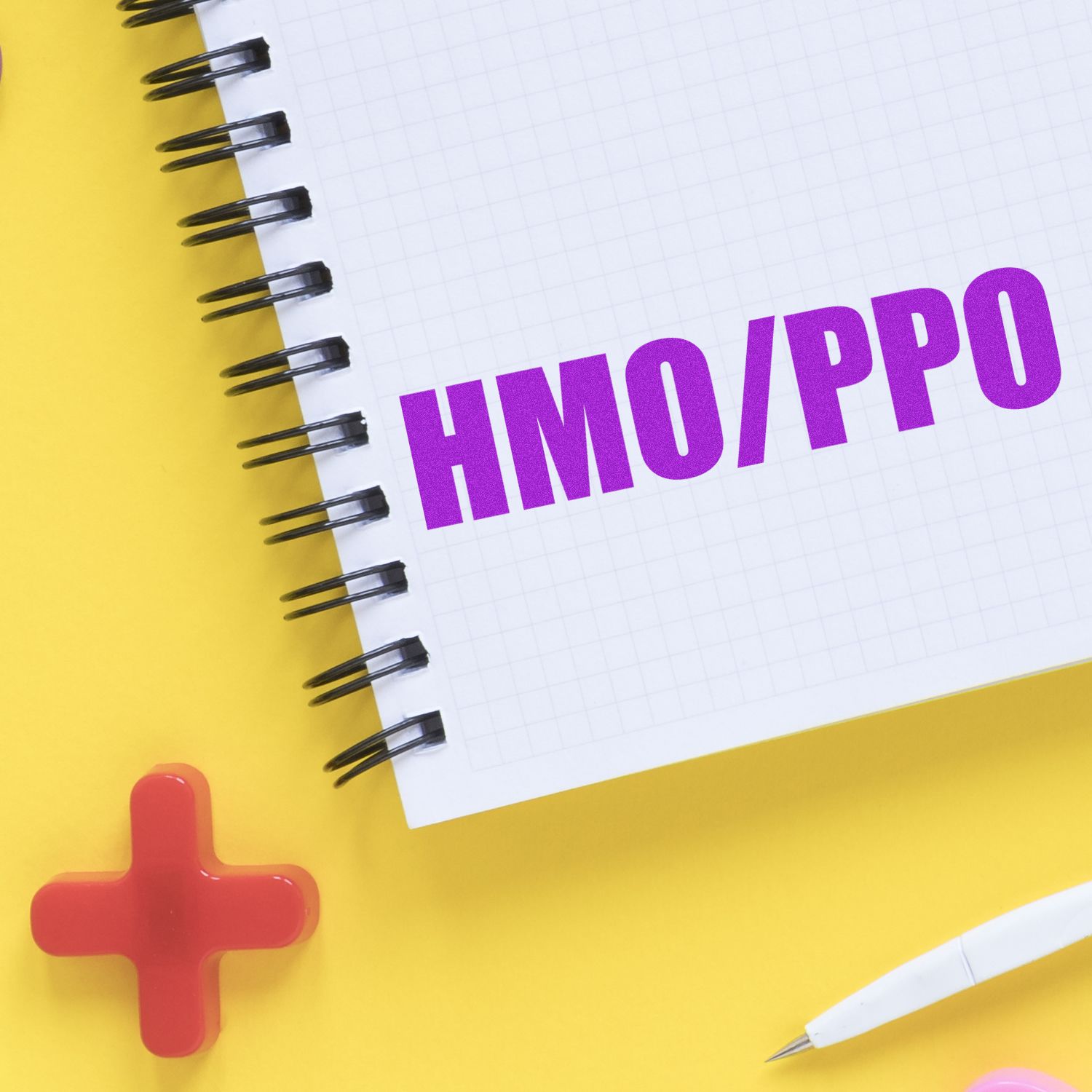 HMO PPO health insurance plans on notebook paper with medical cross and stationery concept image