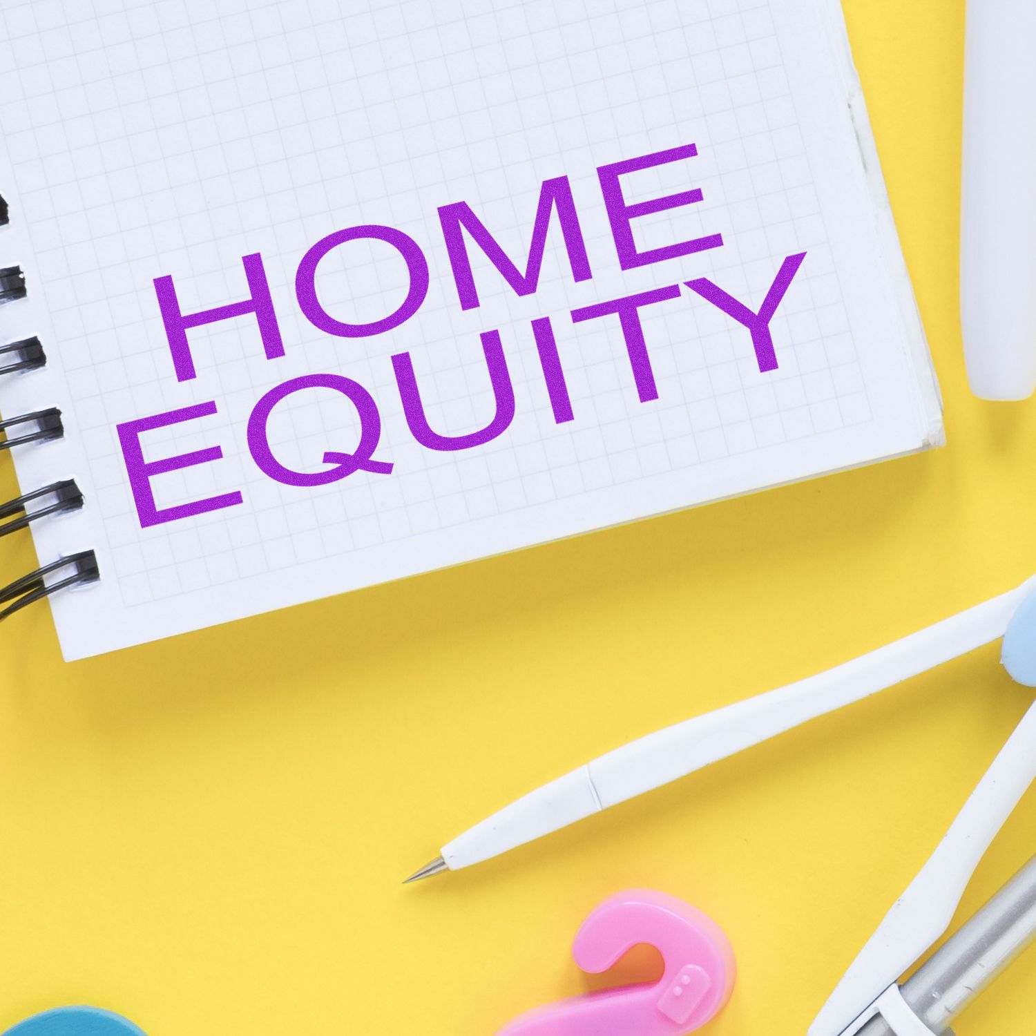 Notebook page with HOME EQUITY text, promoting mortgage and home financing education on a yellow desk with stationery.