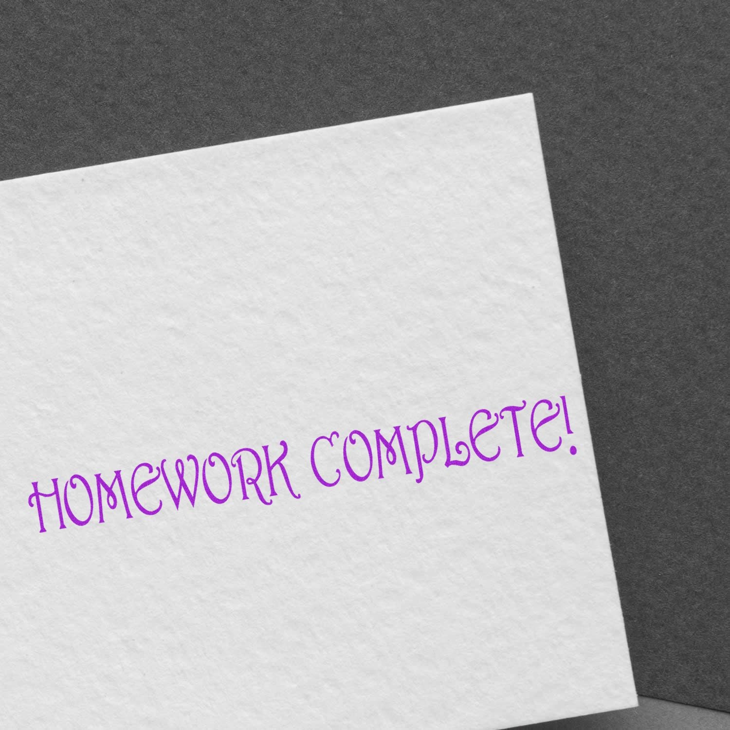 Close-up of a greeting card showing HOMEWORK COMPLETE! in purple, celebrating school success and completed assignments for students.