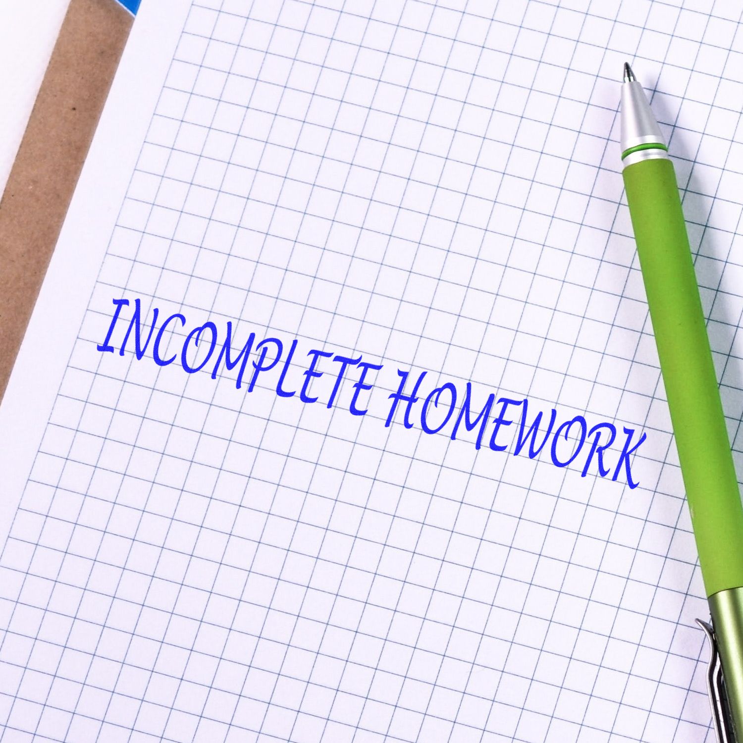 Pen beside graph notebook page with #INCOMPLETEHOMEWORK text, highlighting incomplete homework and student study reminders.