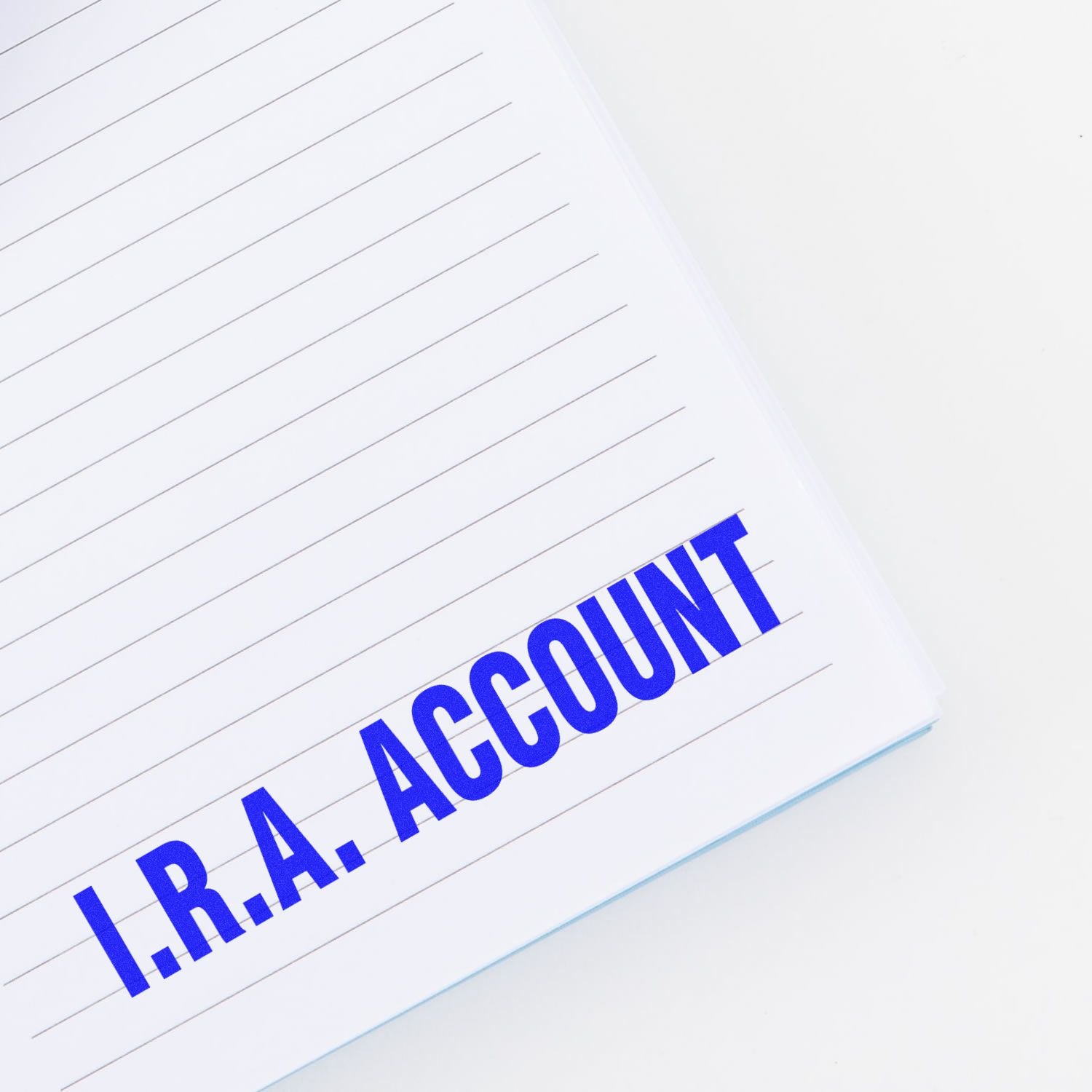 Blue I.R.A. account text on a lined notebook page, representing retirement savings and financial planning.
