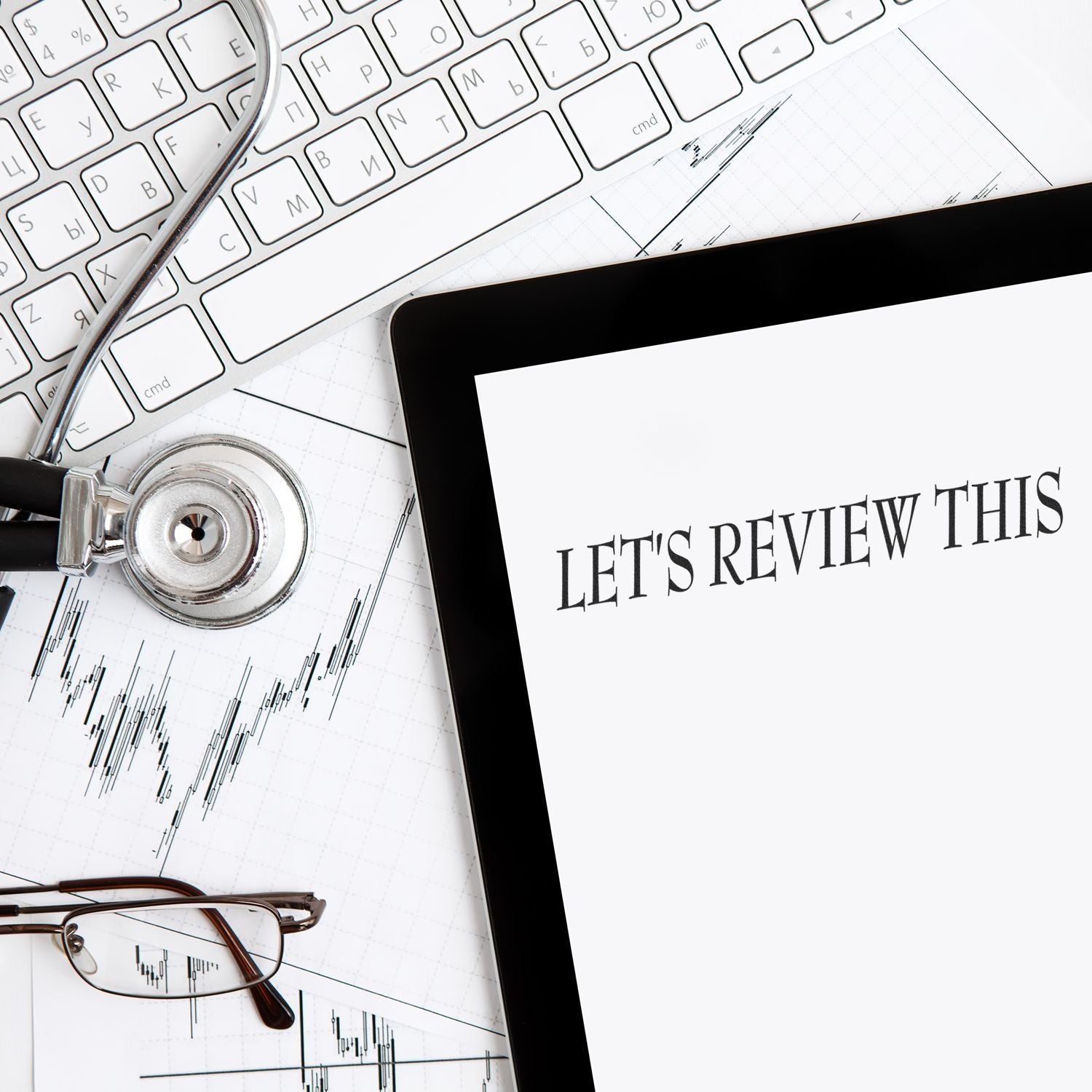 Trading and financial market review concept with stethoscope, investment stock charts, and keyboard background: 'LET'S REVIEW THIS'