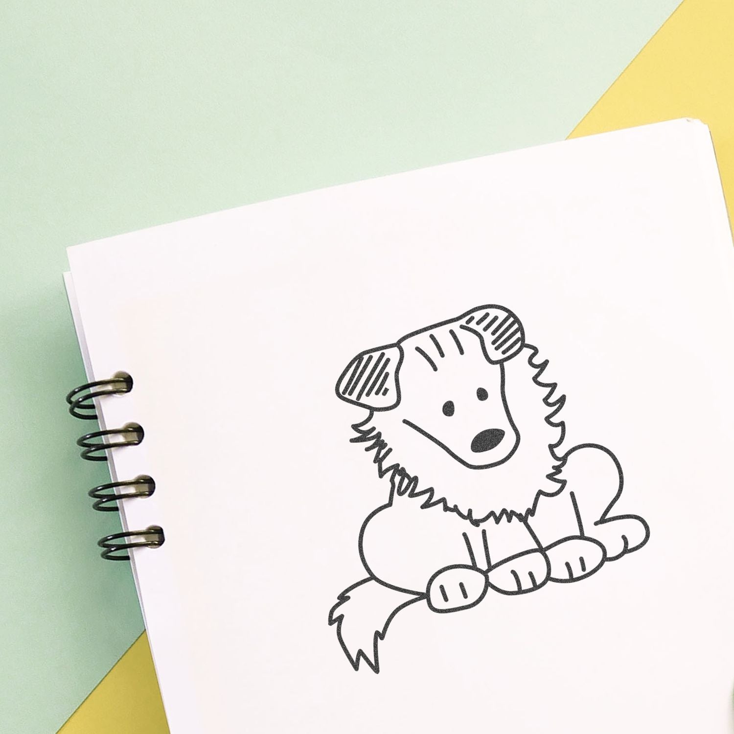 Cute puppy sketch in a spiral notebook on a pastel background, hand-drawn dog illustration.