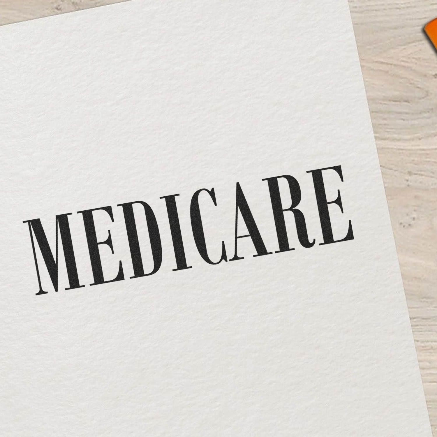 Close-up of paper card printed with MEDICARE text on white cardstock, highlighting the Medicare healthcare program.