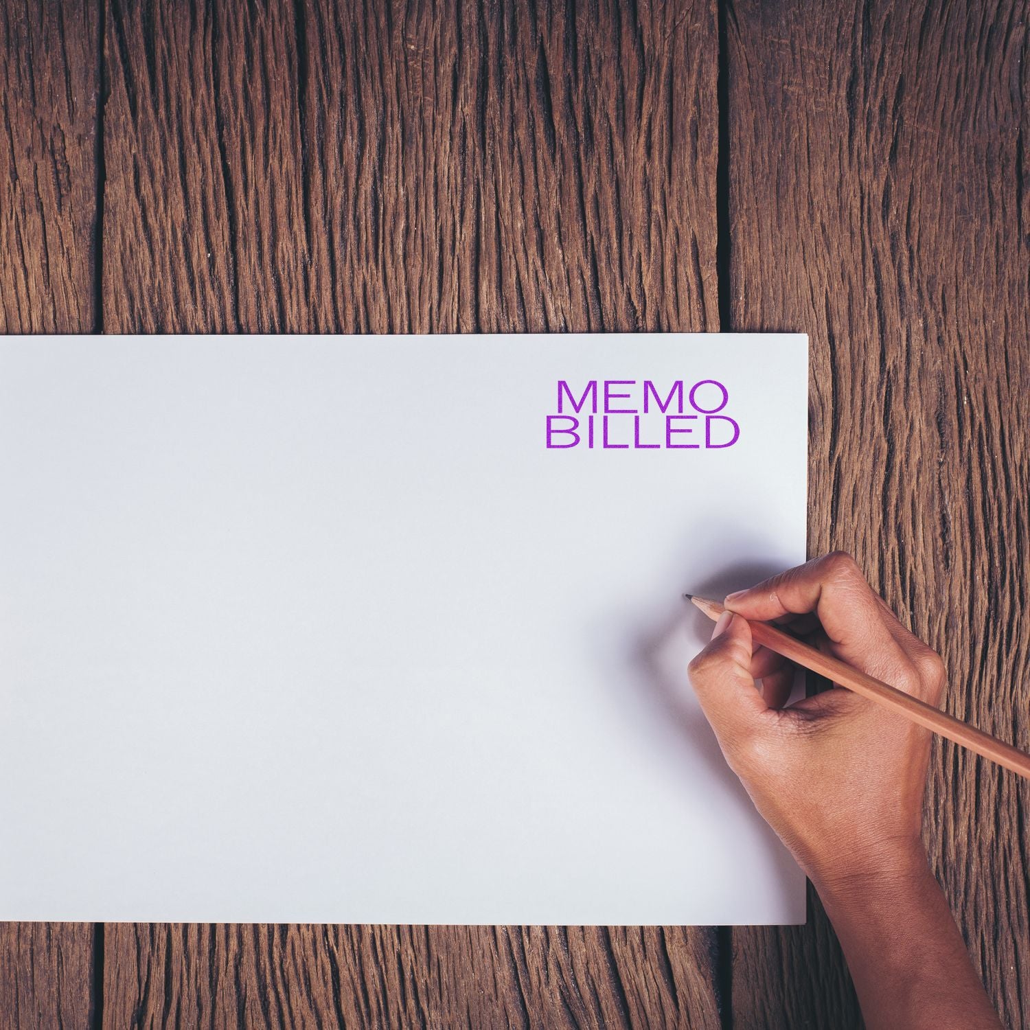 Hand writing business memo on blank sheet with MEMOBILED logo, showing office note-taking and reminders on rustic wooden desk.