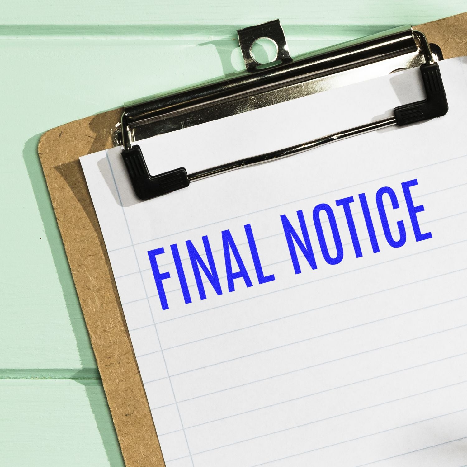 Clipboard with clipped paper reading FINAL NOTICE, signaling an overdue bill warning and payment or legal action.