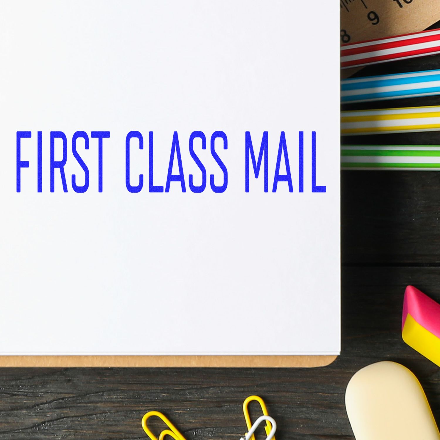 First class mail notebook on desk with colorful stationery supplies and paper clips