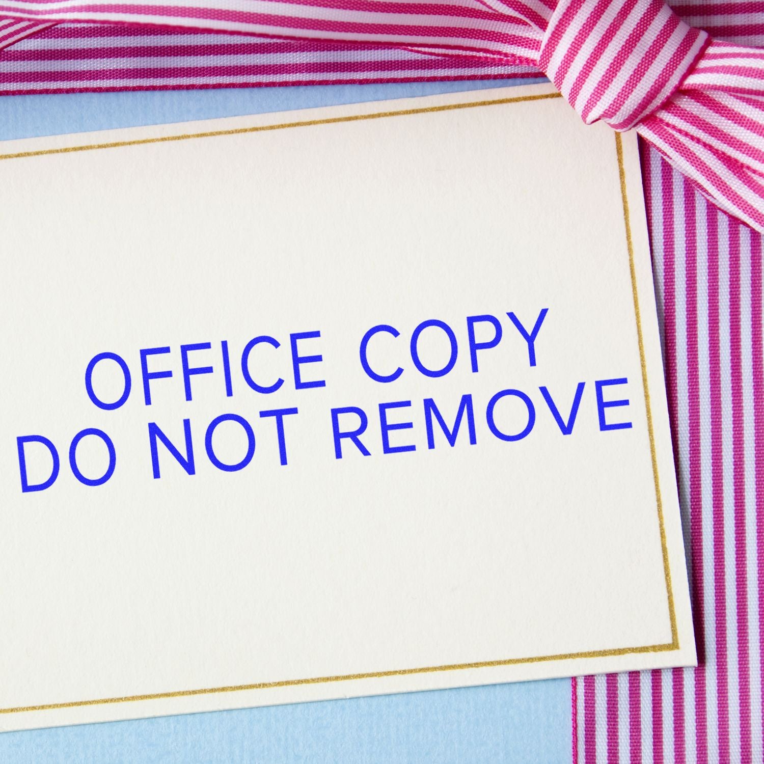 Office copy do not remove card with pink striped ribbon on white stationery background