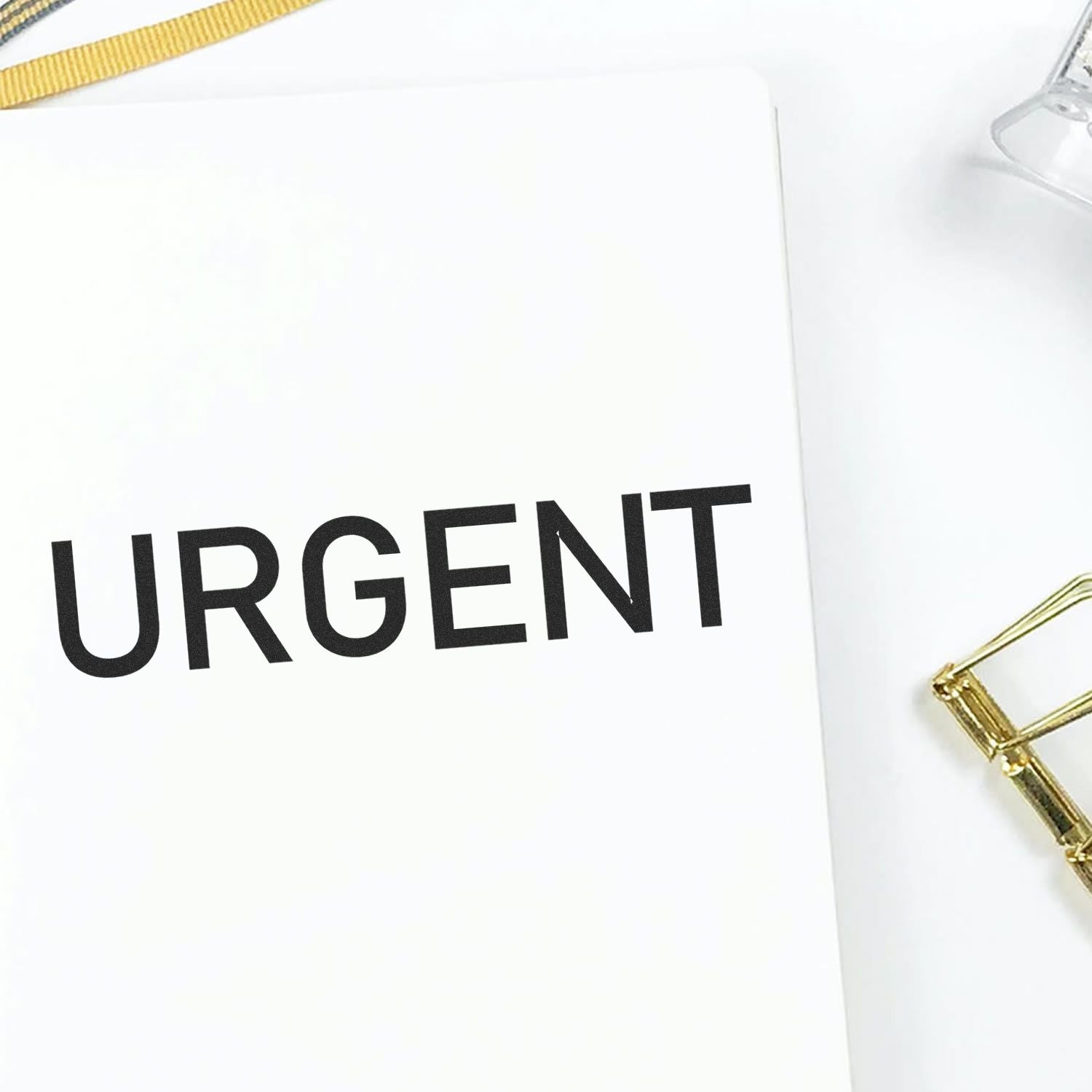 White folder marked URGENT with gold clasp, highlighting priority shipping or urgent document handling notice.