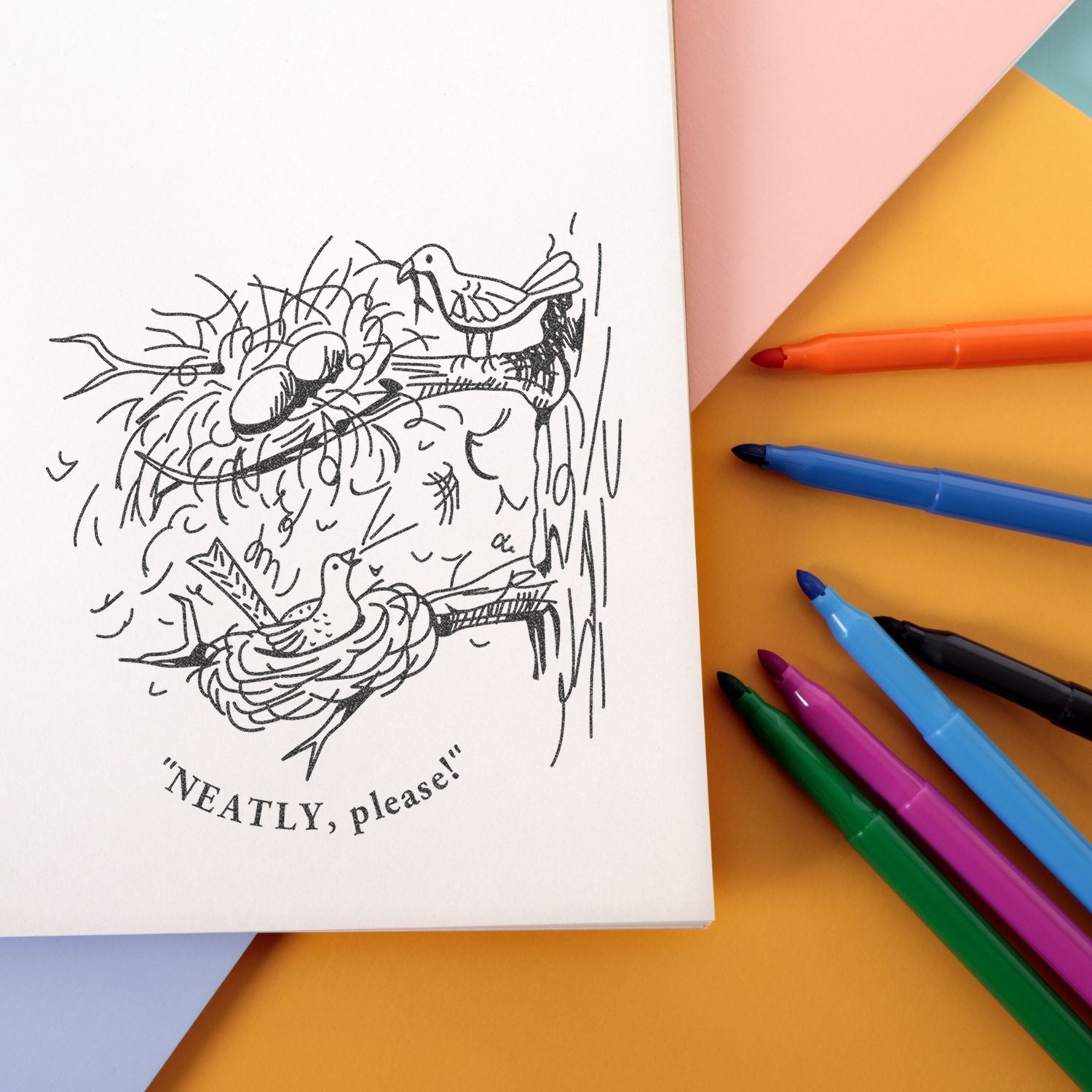 Notebook with bird nest doodle and NEATLY, please! text, surrounded by colorful markers on a pastel background.