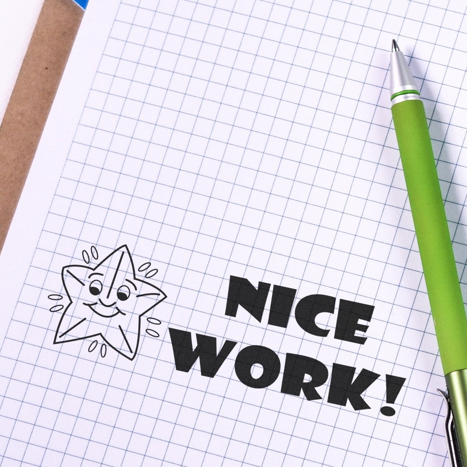 Motivational Nice Work! text on graph paper notebook with green pen and cute star doodle.