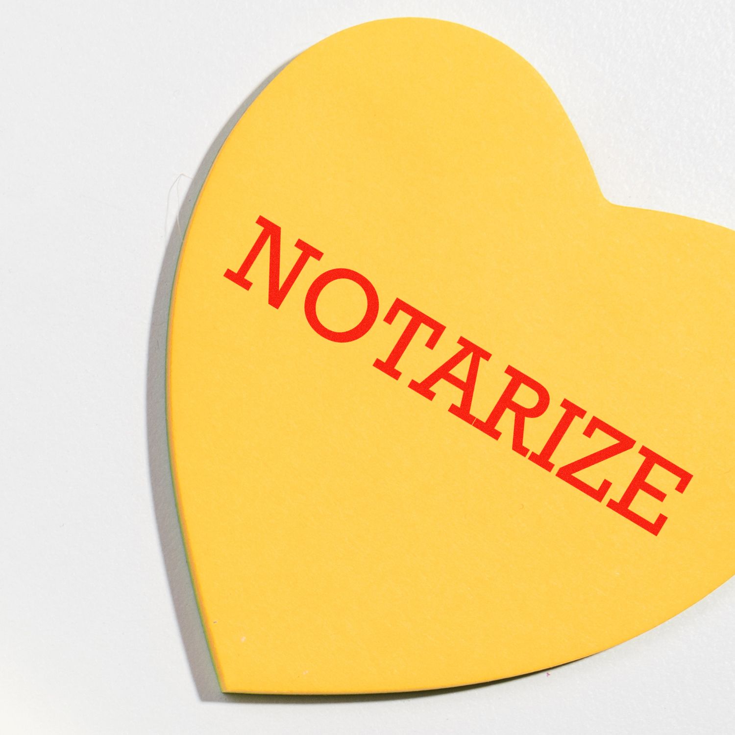 Yellow heart-shaped note with red NOTARIZE text, symbolizing notary and document notarization services.