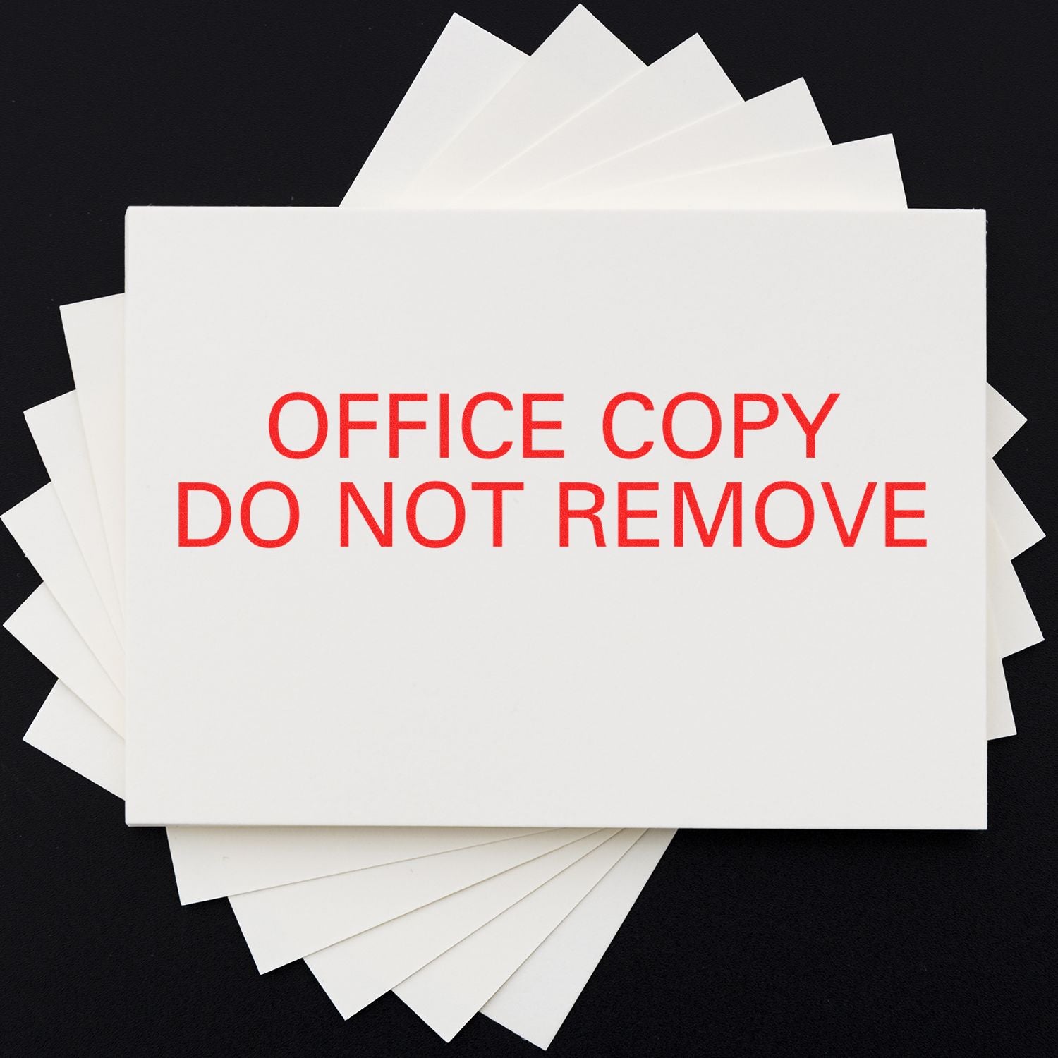 Stack of office copy documents with prominent red label DO NOT REMOVE, indicating document retention and office management warning.