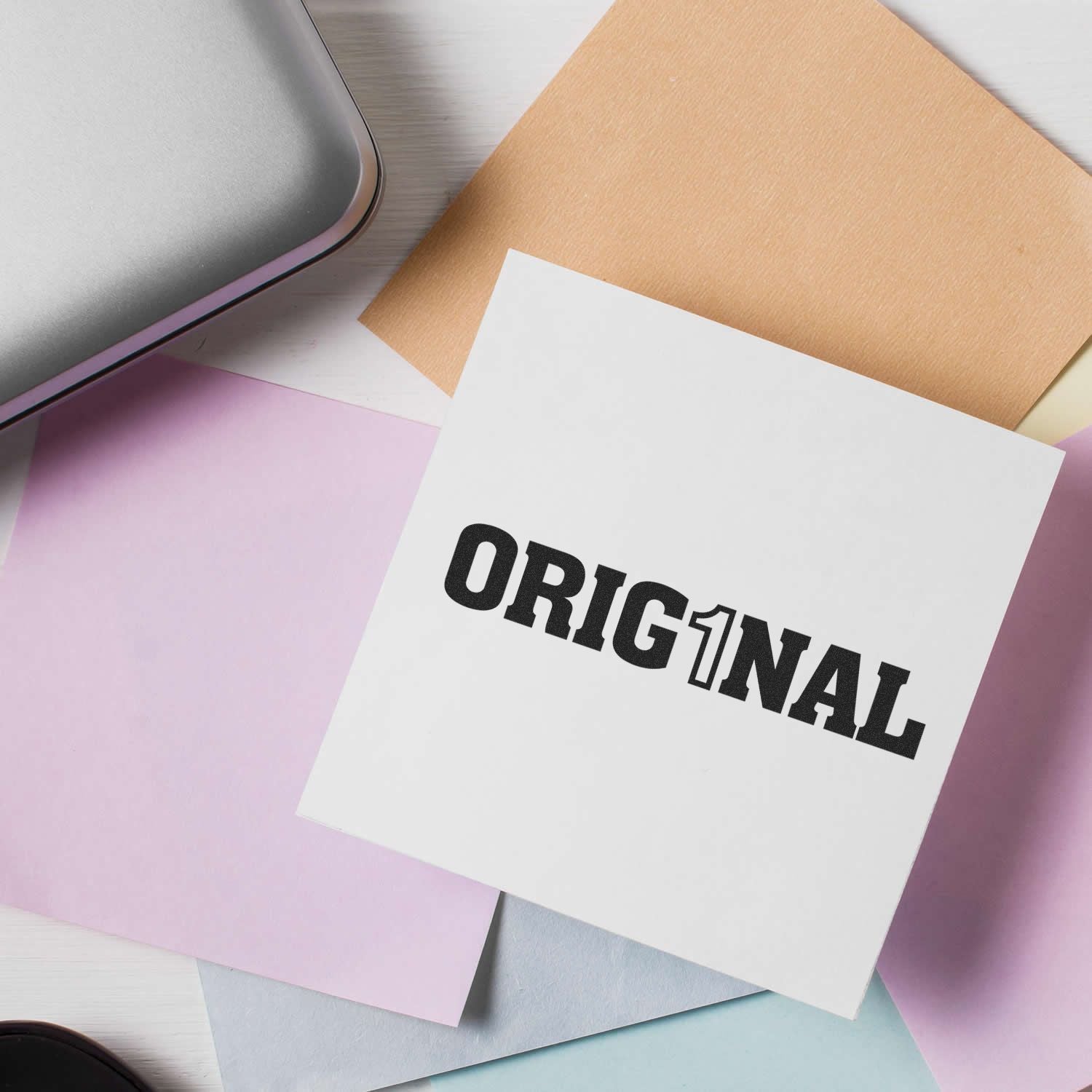 ORIGINAT logo on printed cards atop colorful stationery notes, representing brand identity branding and creative design marketing.
