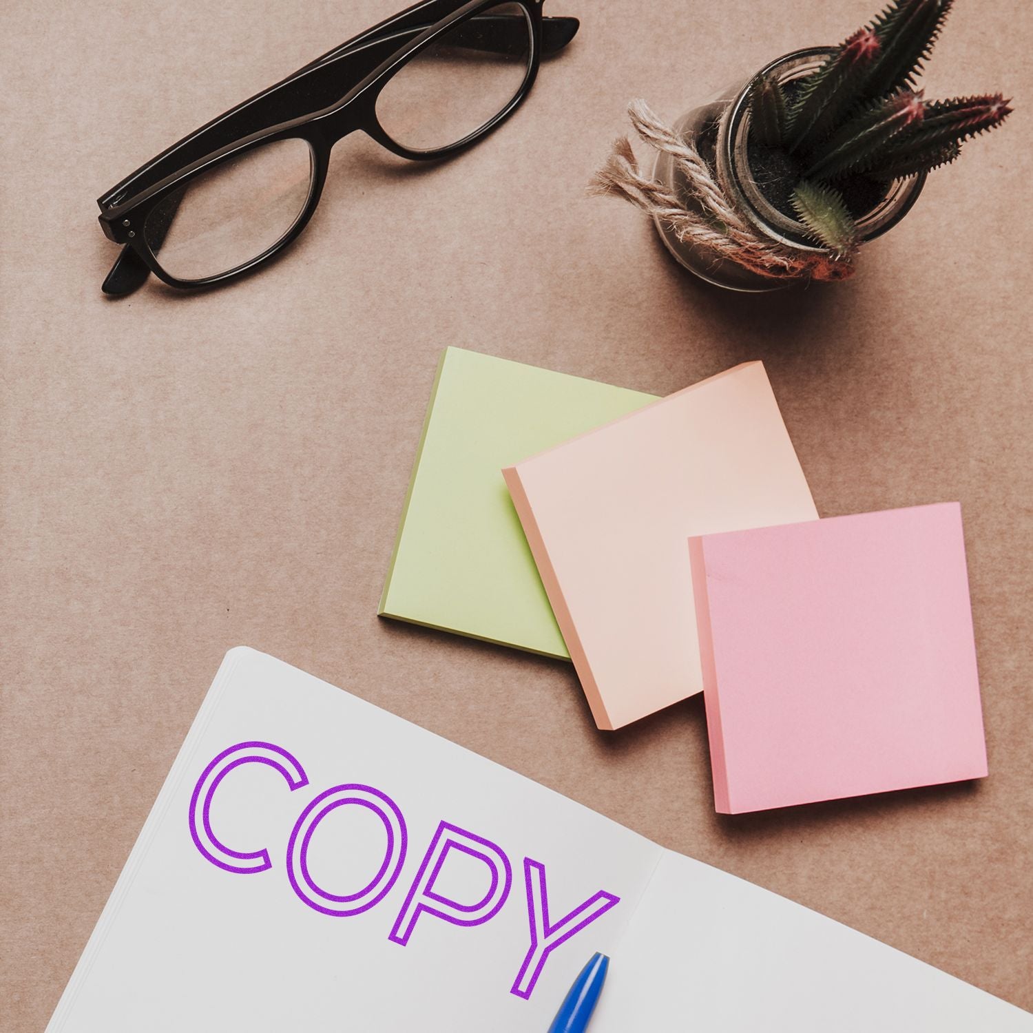 Flat lay of office supplies: colorful notebooks, sunglasses, and COPYcreative writing and marketing advertising copy planning.