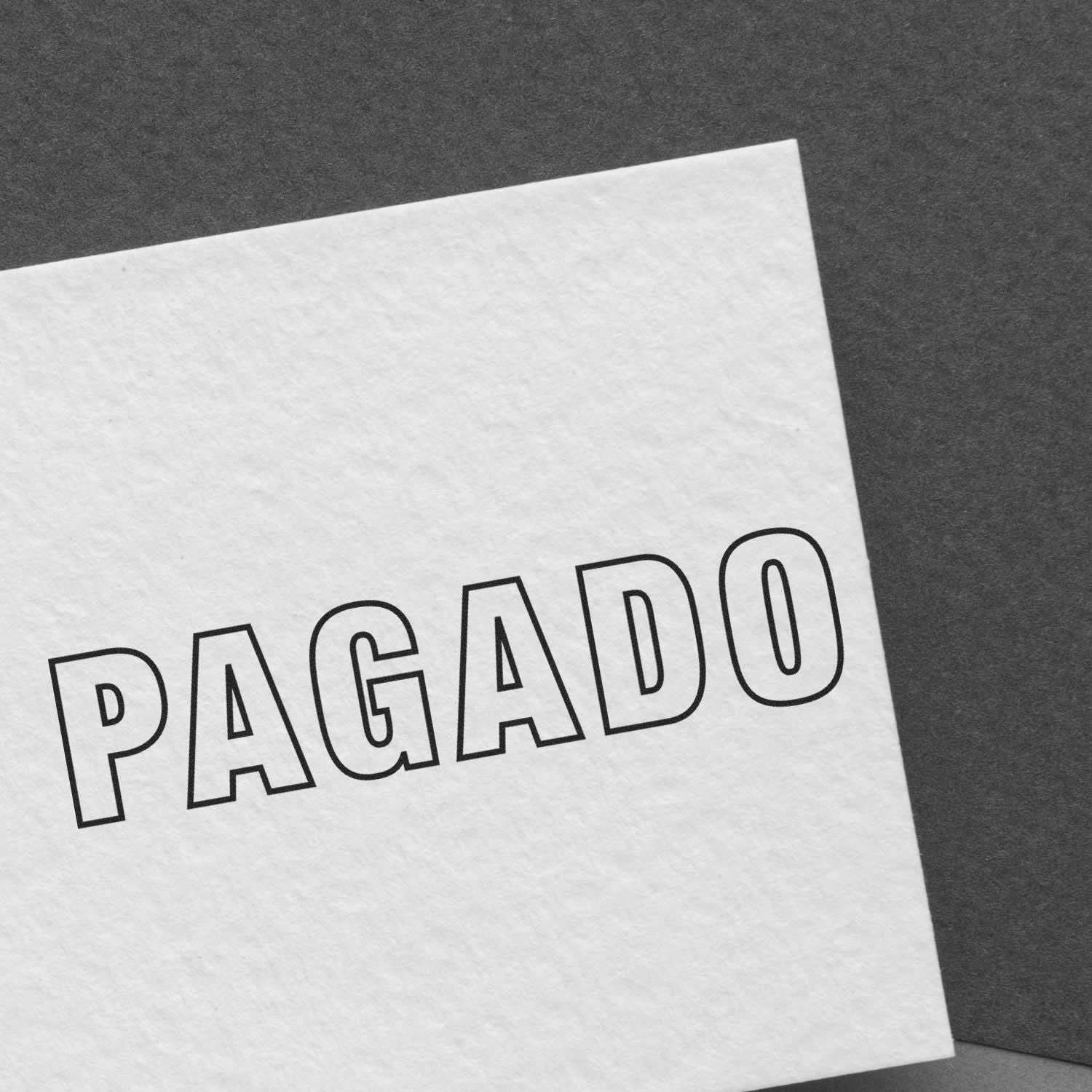 Documento con la palabra PAGADO impresa en papel blanco sobre fondo oscuro.
