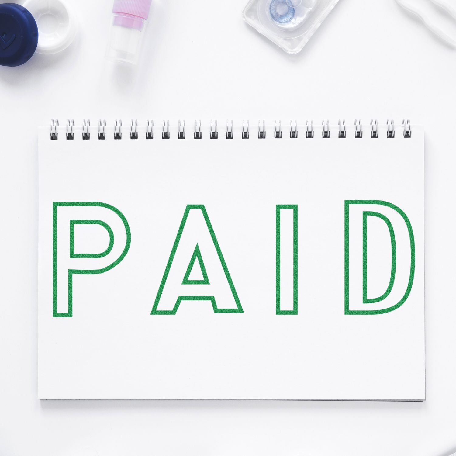 Paid receipt notebook with green PAID text and medical supplies on clean white background for healthcare billing context