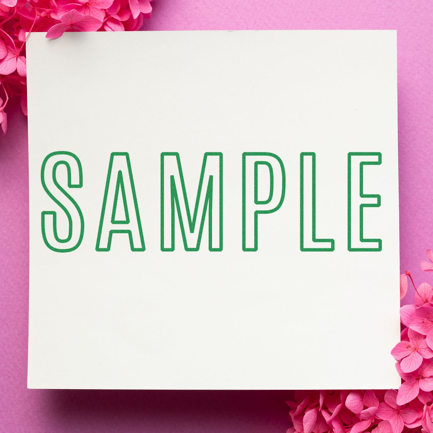 Pink floral background with white card mockup showing SAMPLE in green, for design or greeting message space