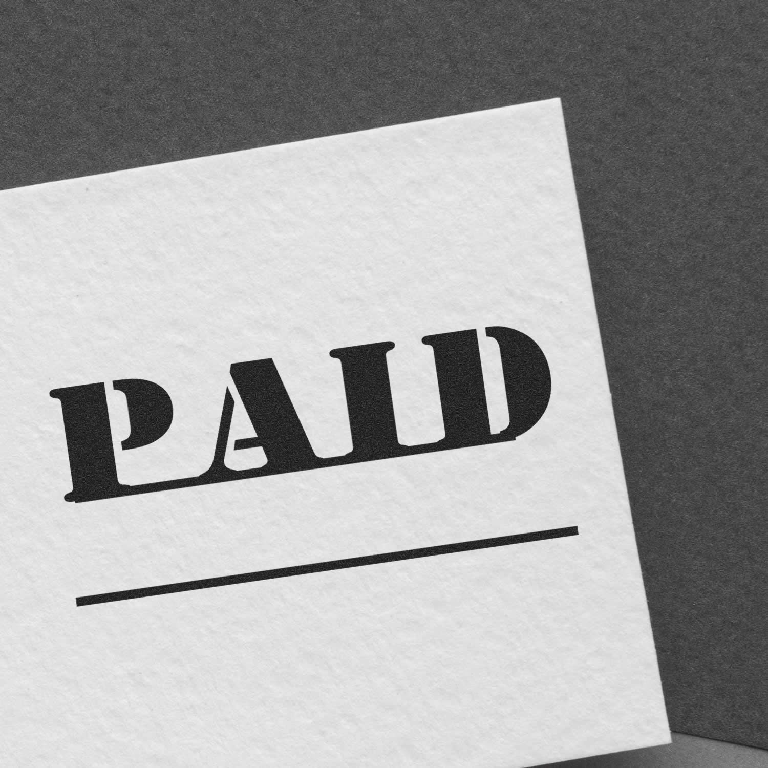 Close-up of a paid stamp on white paper, indicating invoice or bill payment confirmation.